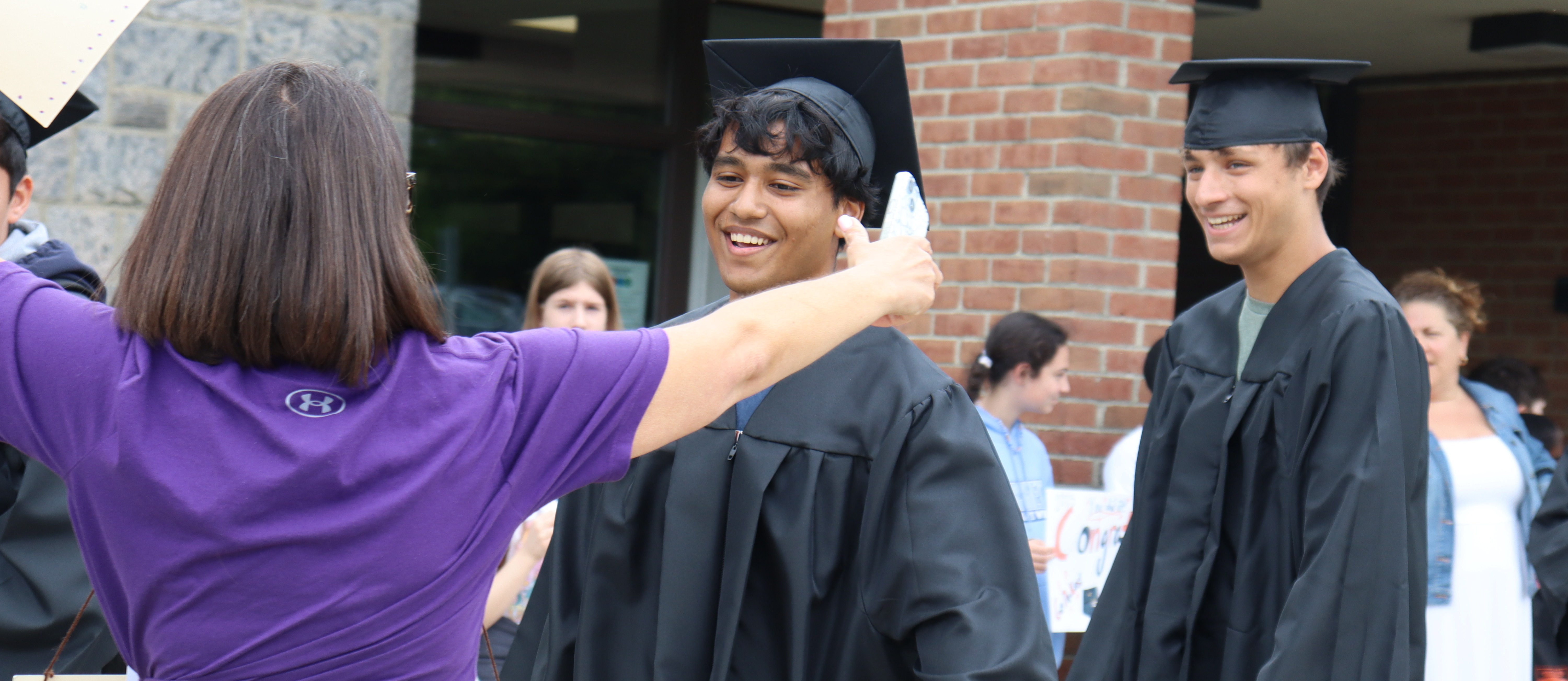 A graduate hugs a teacher