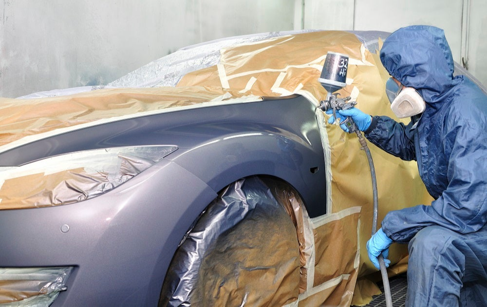 Photo of a person painting a fender activity.