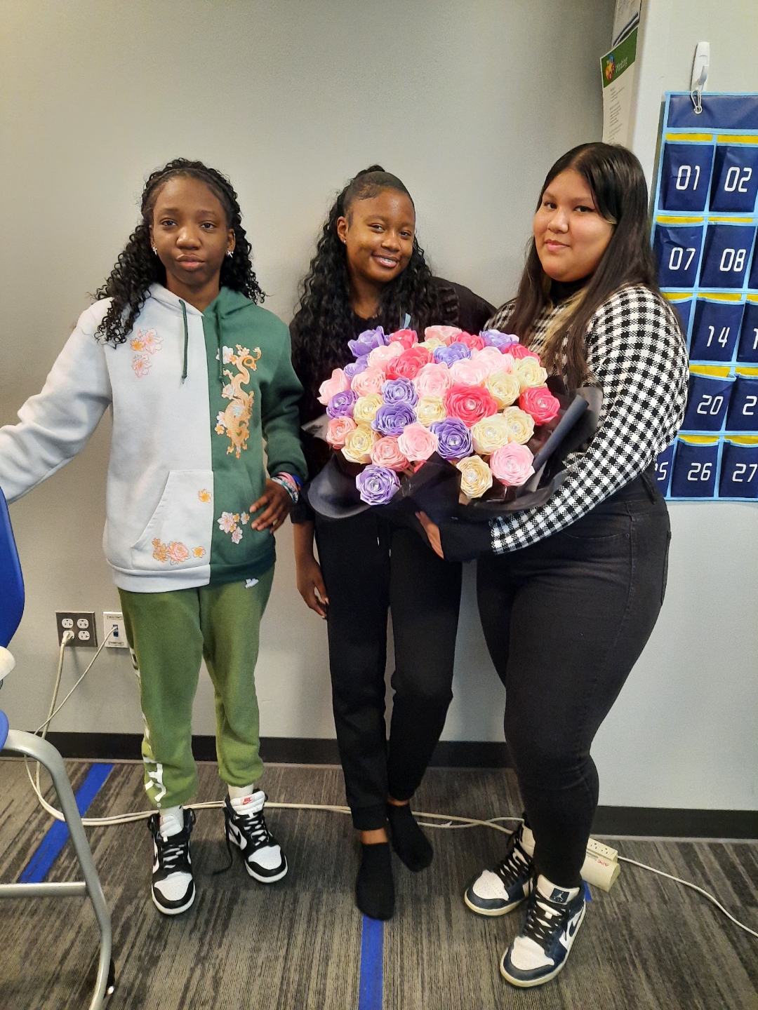 female students holding a bouquet of ribbon flowers