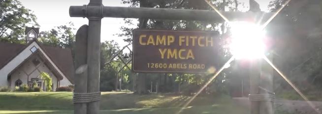 Camp Fitch YMCA Sign with building in the background
