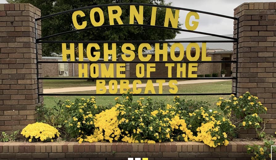 Corning High School home of the bobcats yellow words on sign with yellow flowers in front
