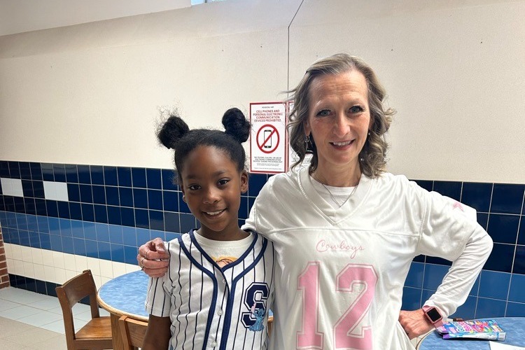 a small student and a teacher high fiving 