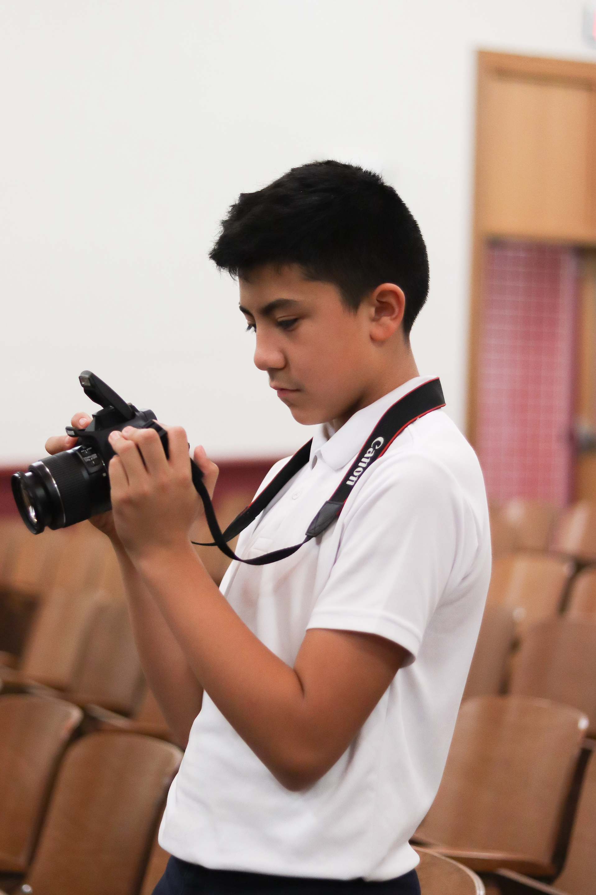 male student taking a picture with a digital camera