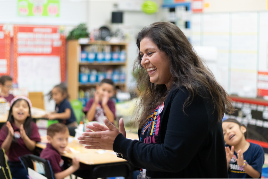 teacher clapping for a student in class