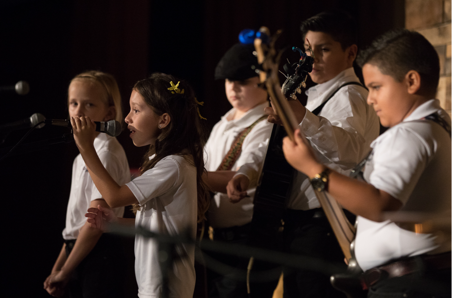 students performing on stage as a band