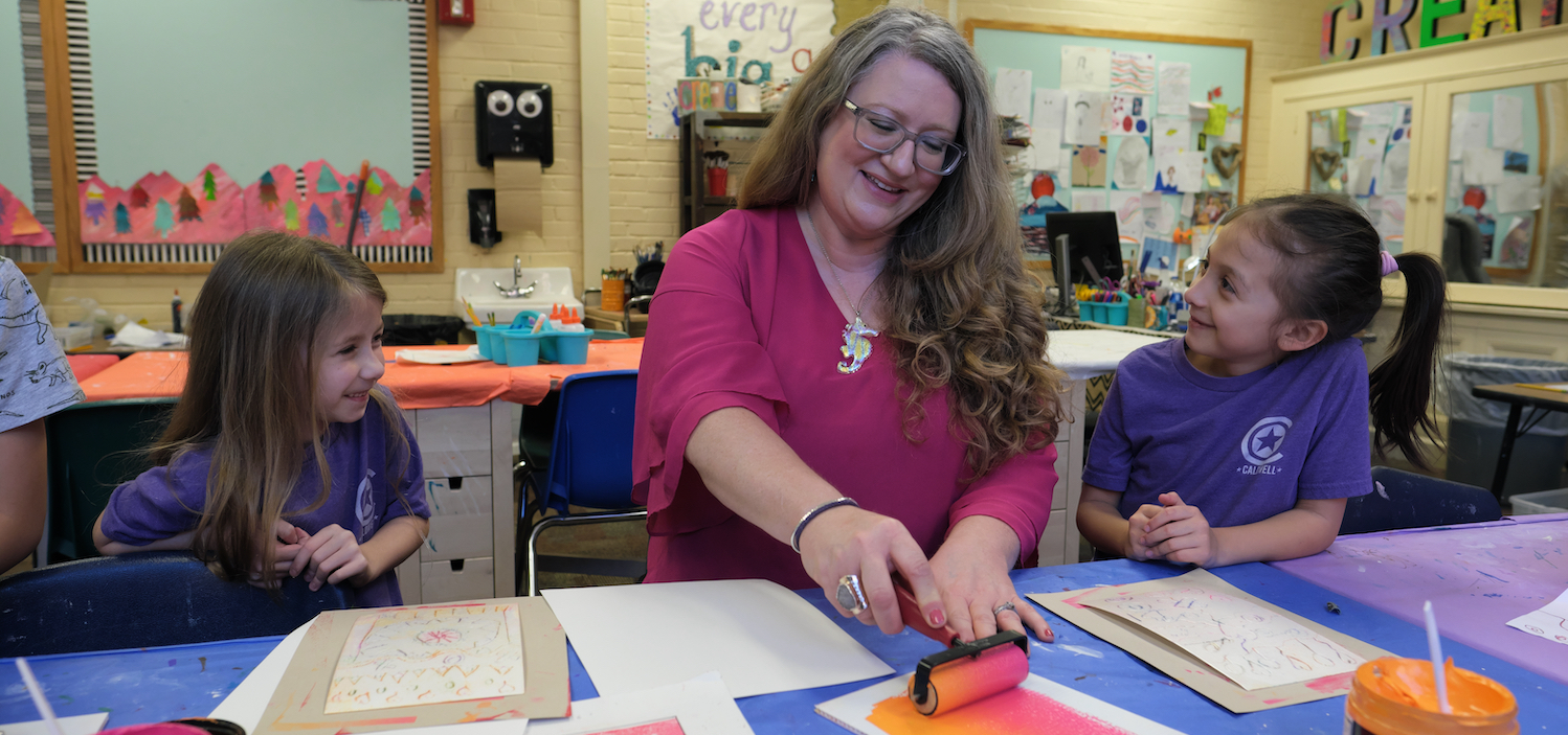 students with teacher painting