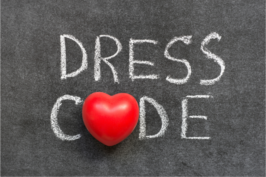 Dress code written in chalk on a black board with a red heart replacing the O  in CODE