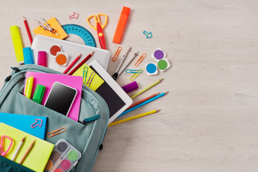school supplies coming out of a blue backpack