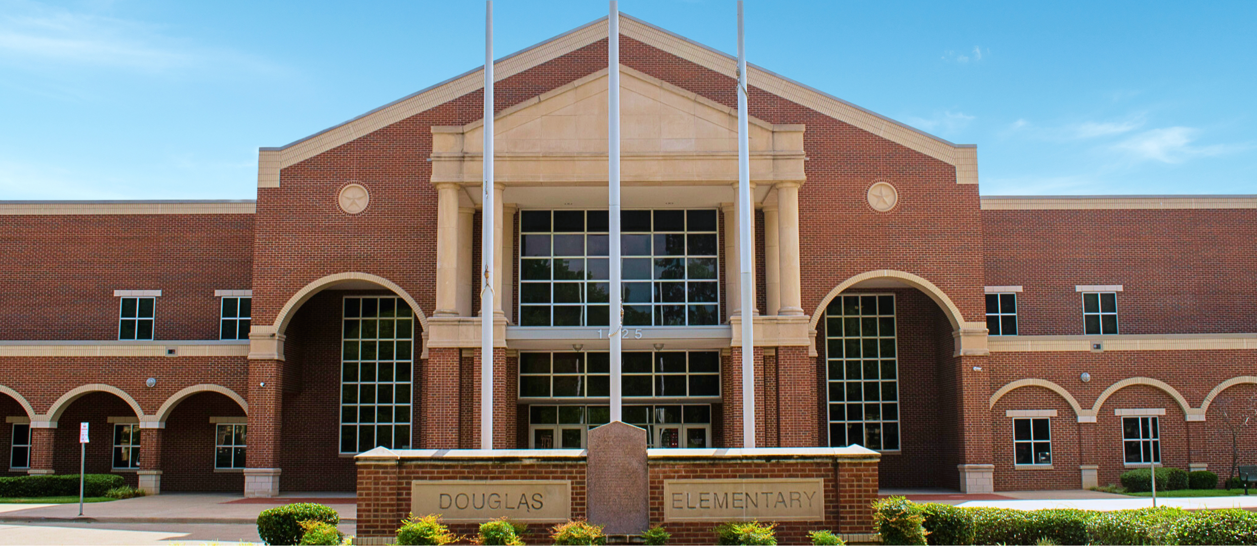 Douglas Elementary Red Brick Building main entrance in front of 3 flag poles