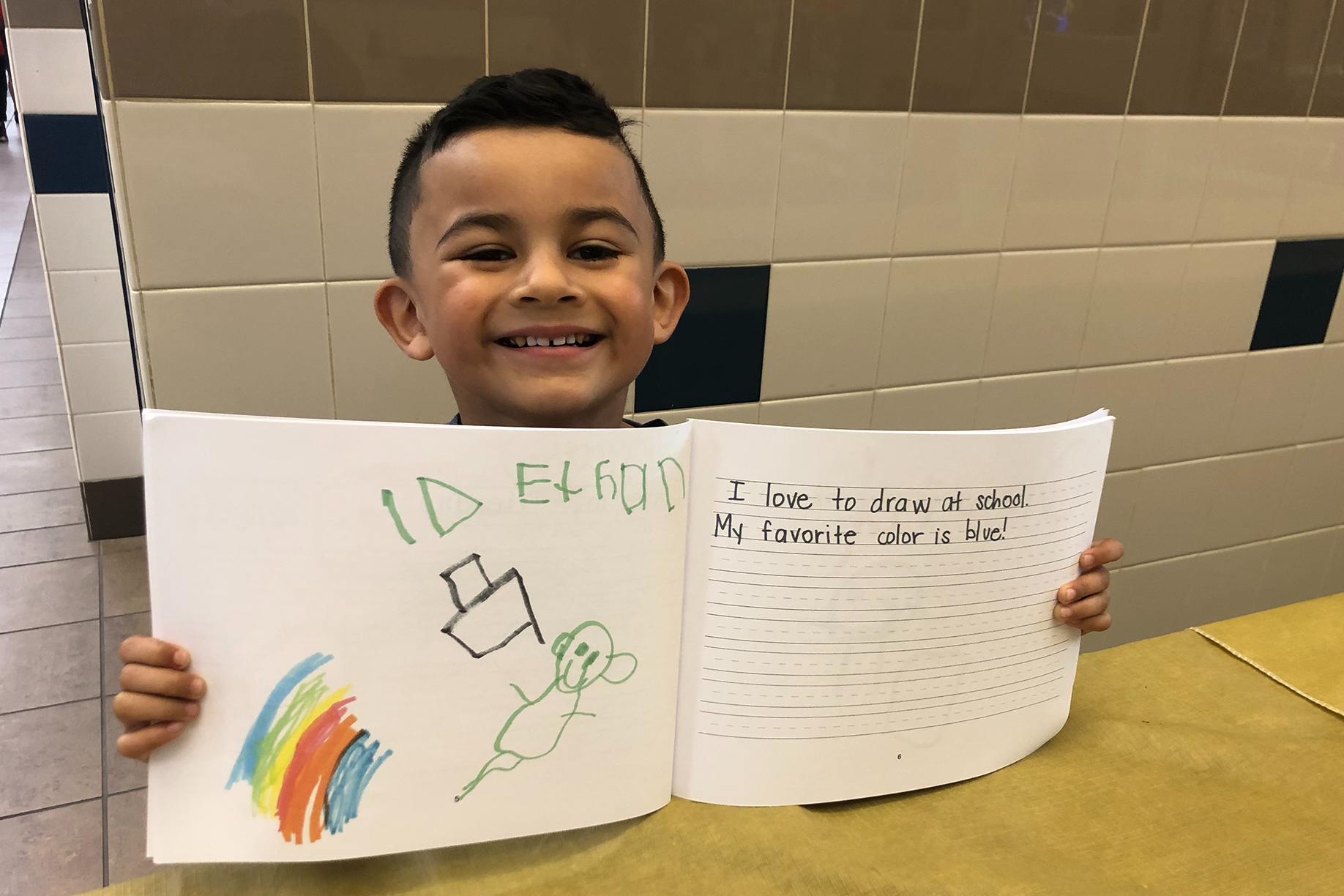 elementary age boy holding a book open