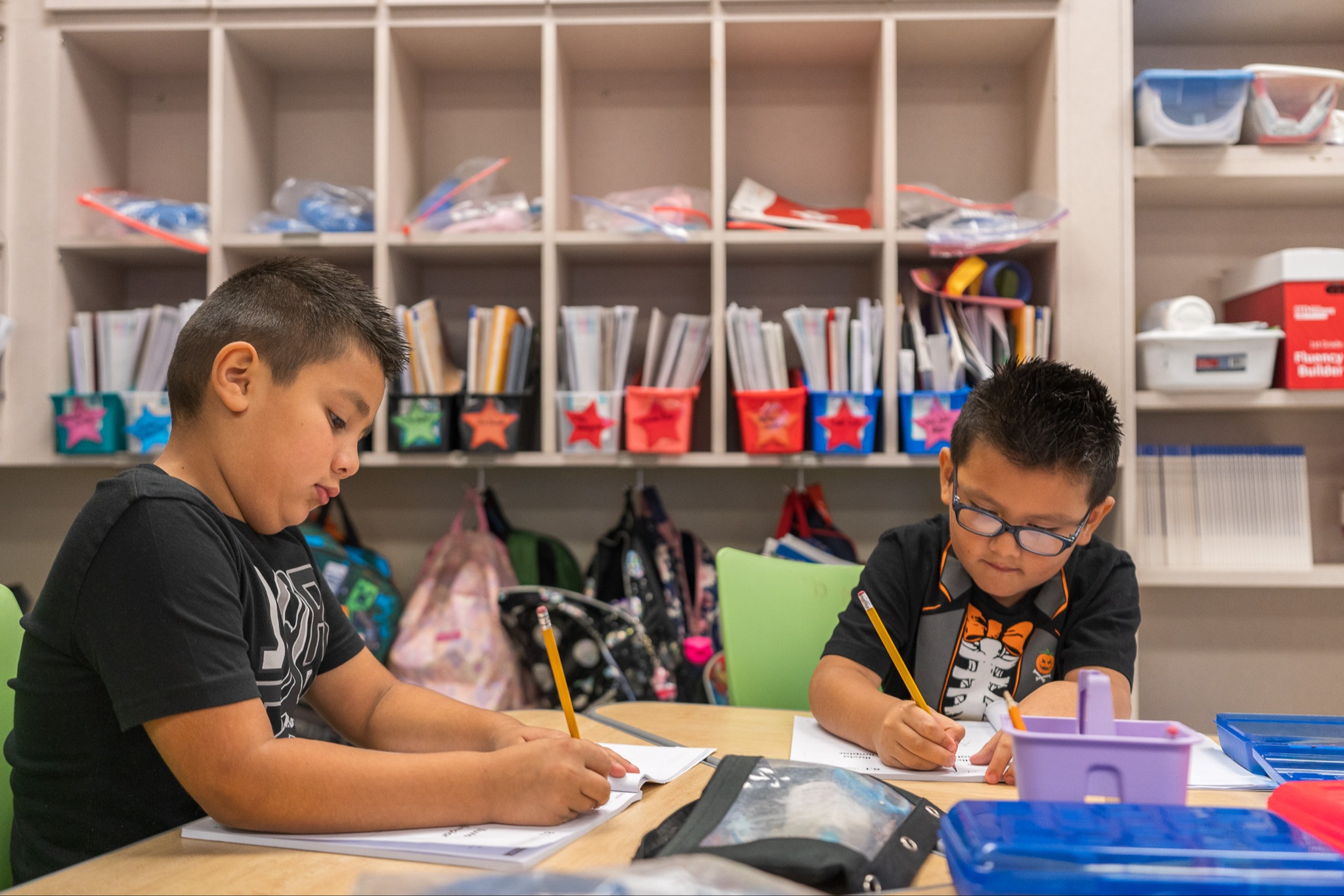 elementary boys working on schoolwork at a table