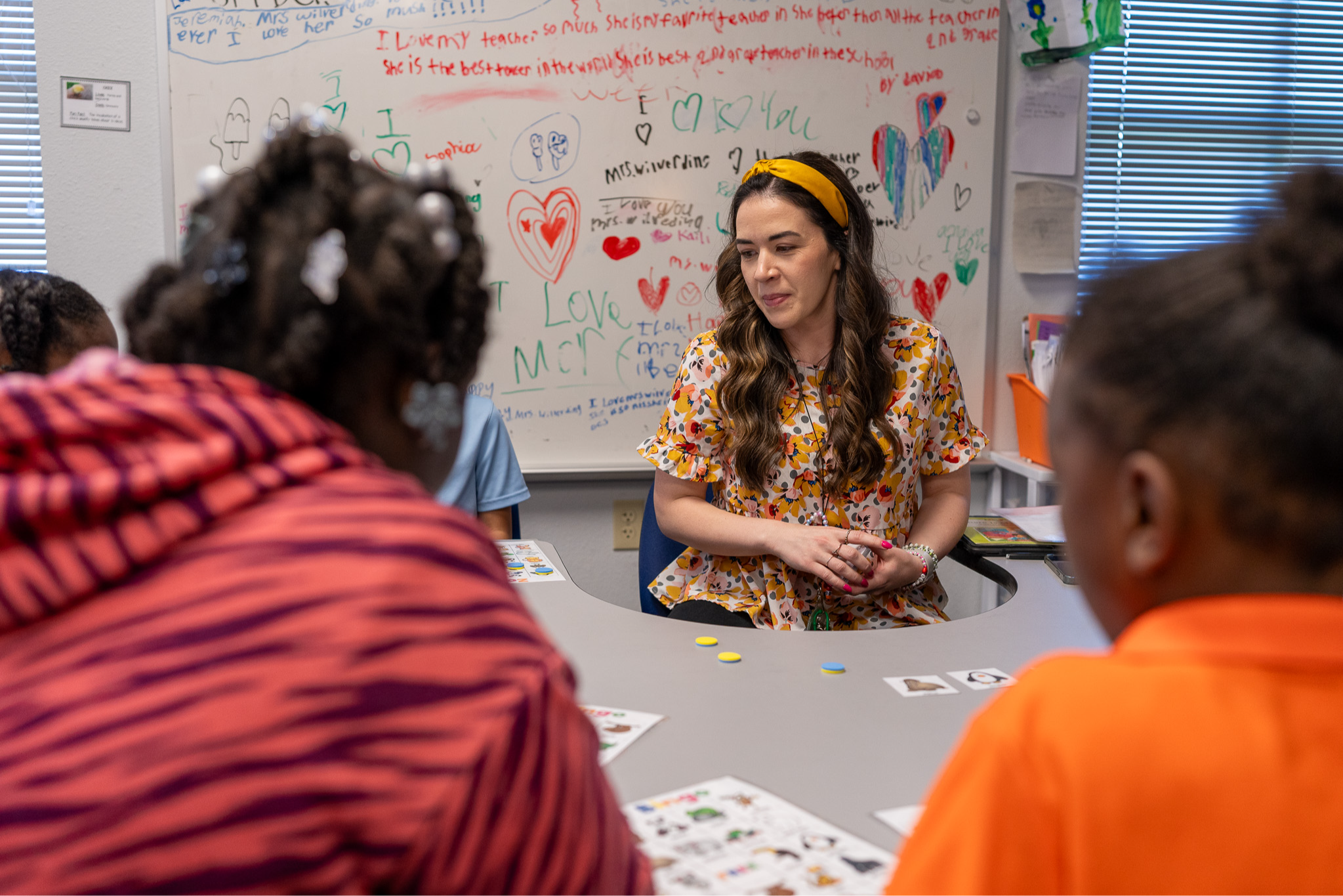 teacher at a table with two students in front of her