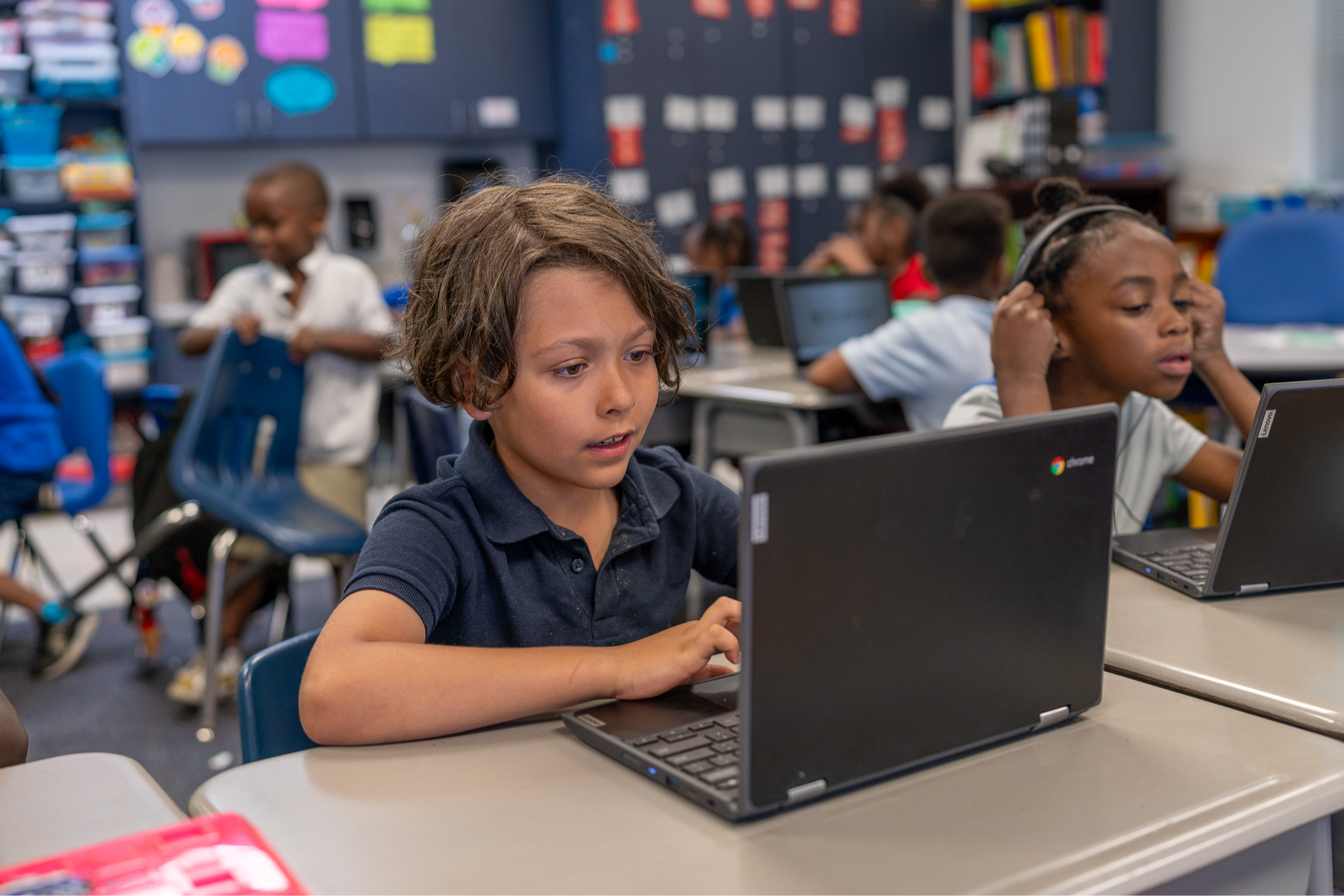 elementary students working on laptops