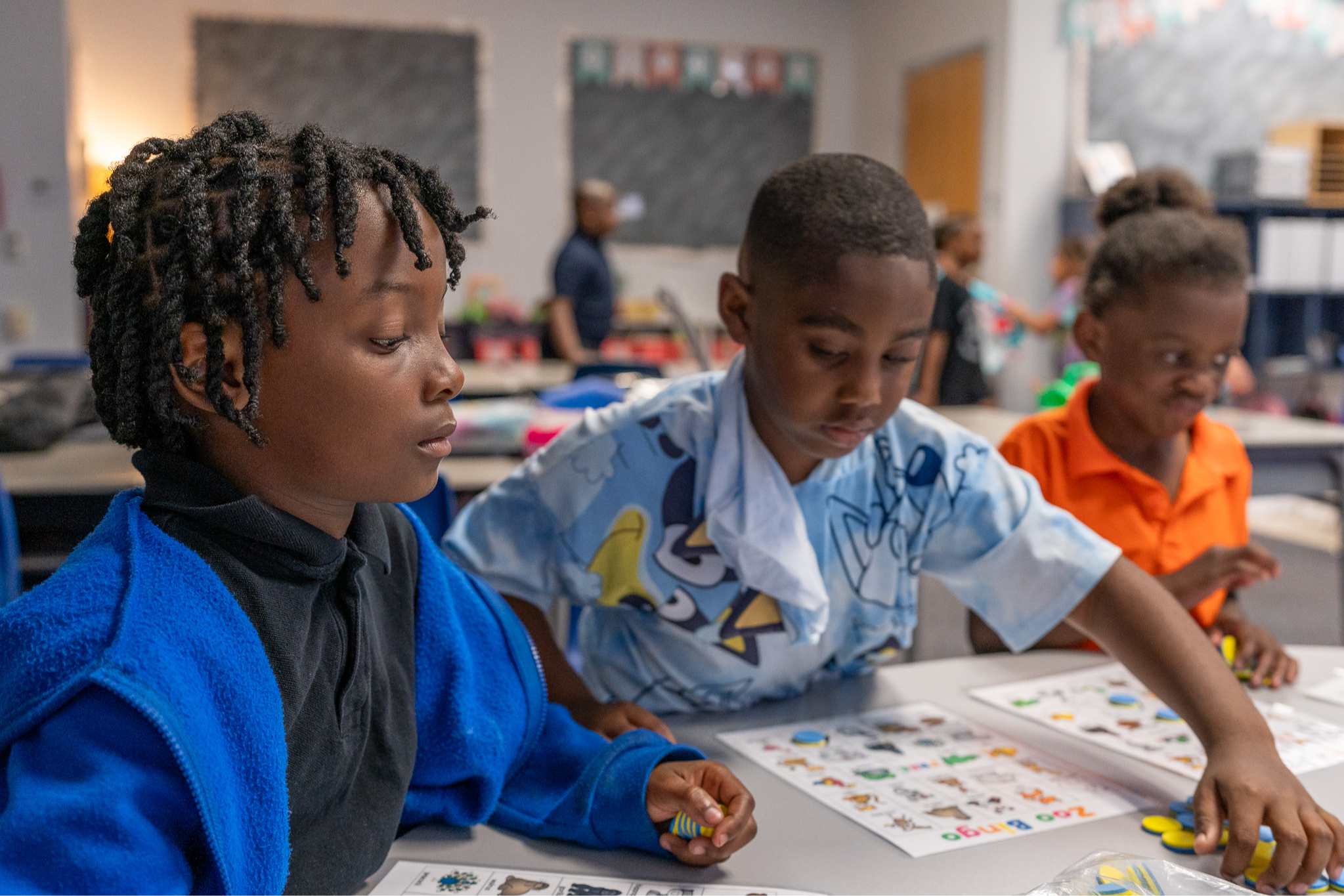 elementary students doing worksheets at a table