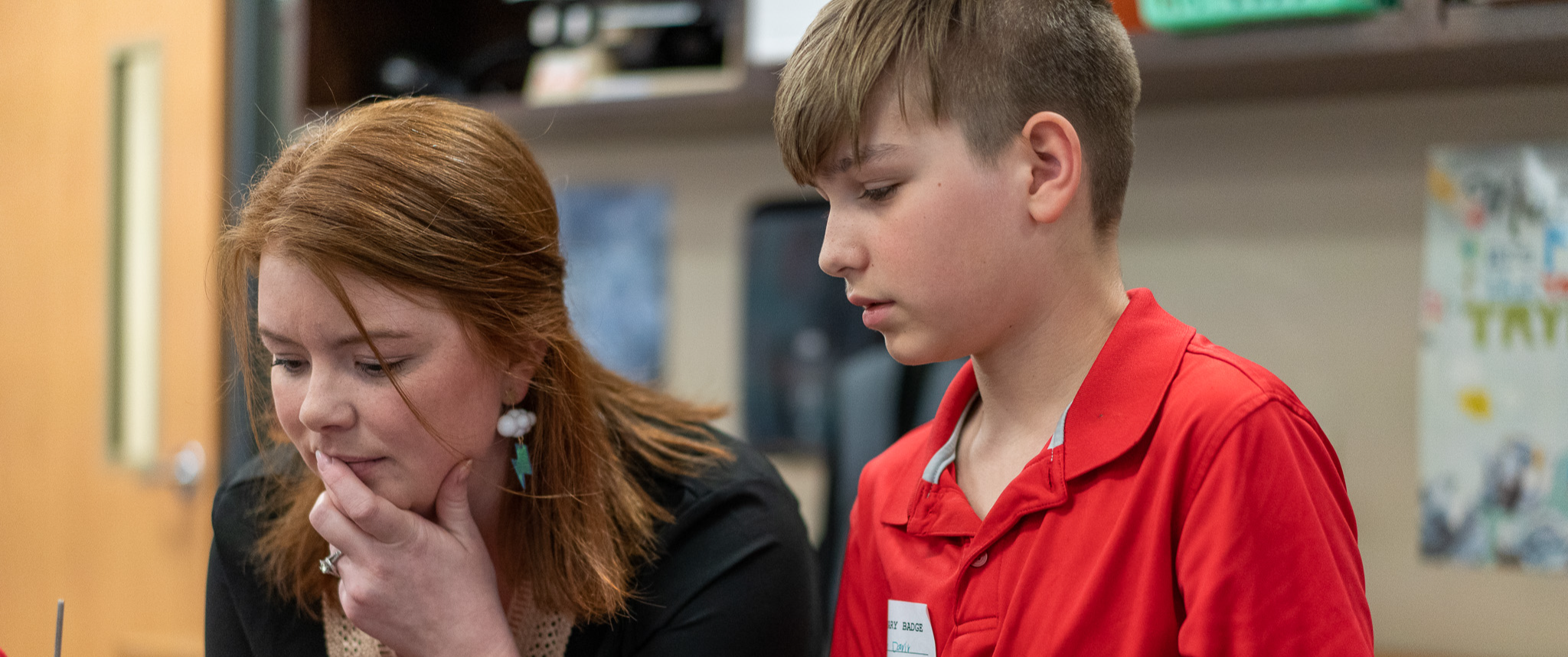 teacher working with student on STEM