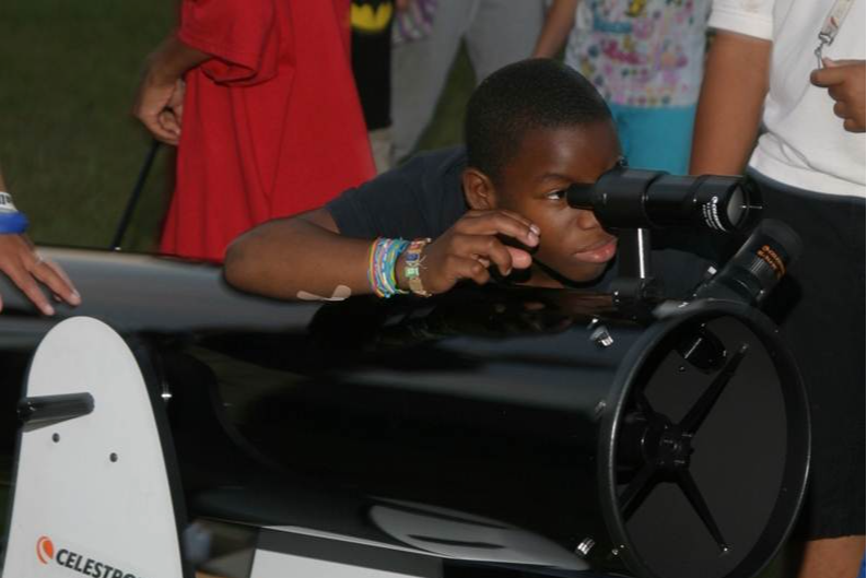 student looking through telescope