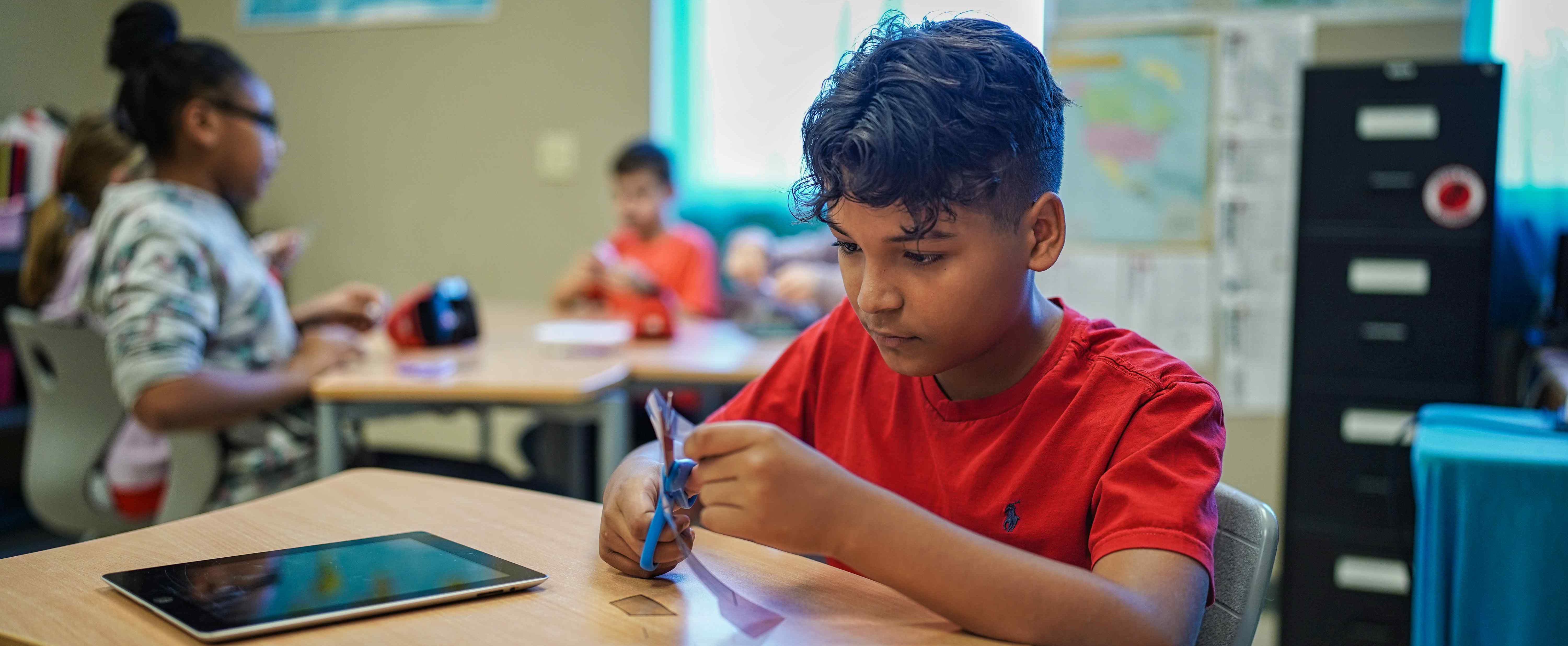 student cutting with scissors 