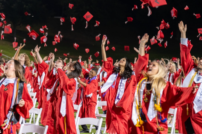 Tyler Legacy seniors at graduation throwing their caps in the air