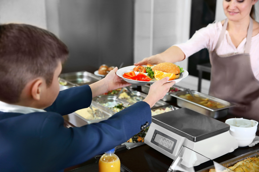 Student getting plate of food in a cafeteria