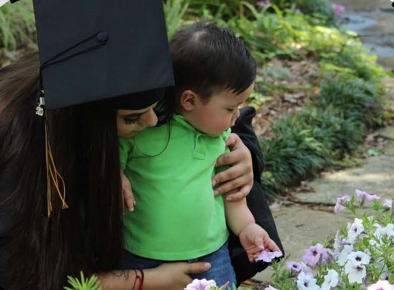female graduate and child posing in Tyler Rose Garden