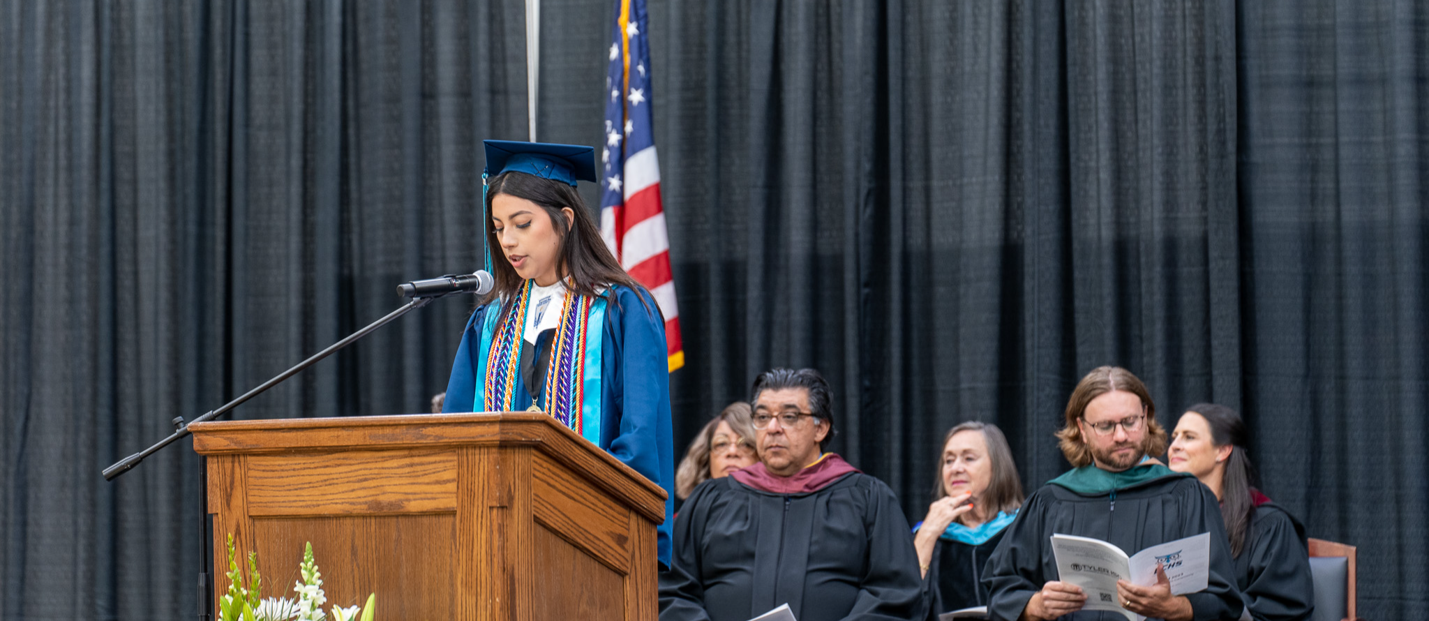 student holding both degree and diploma