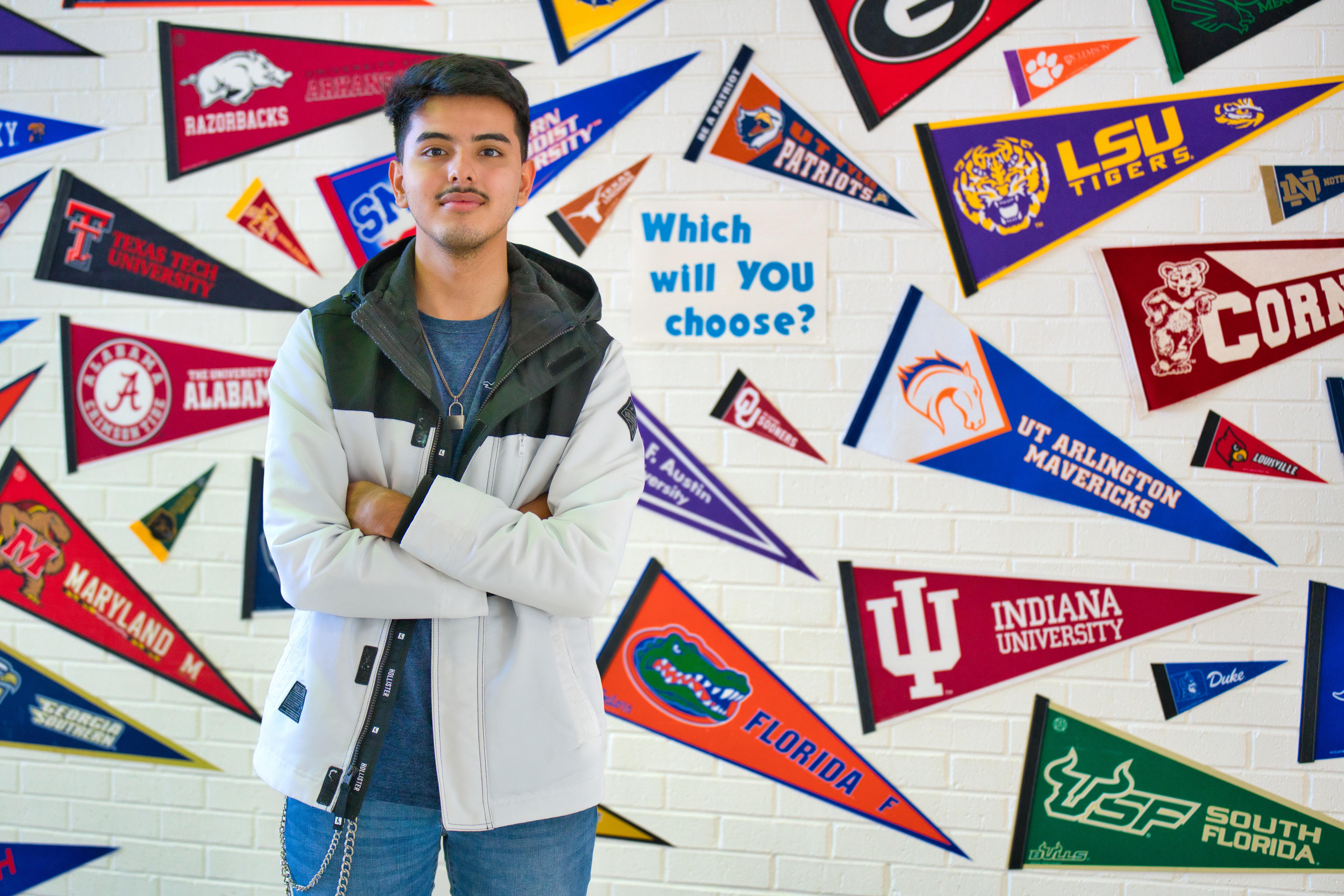 student in front of college pennants