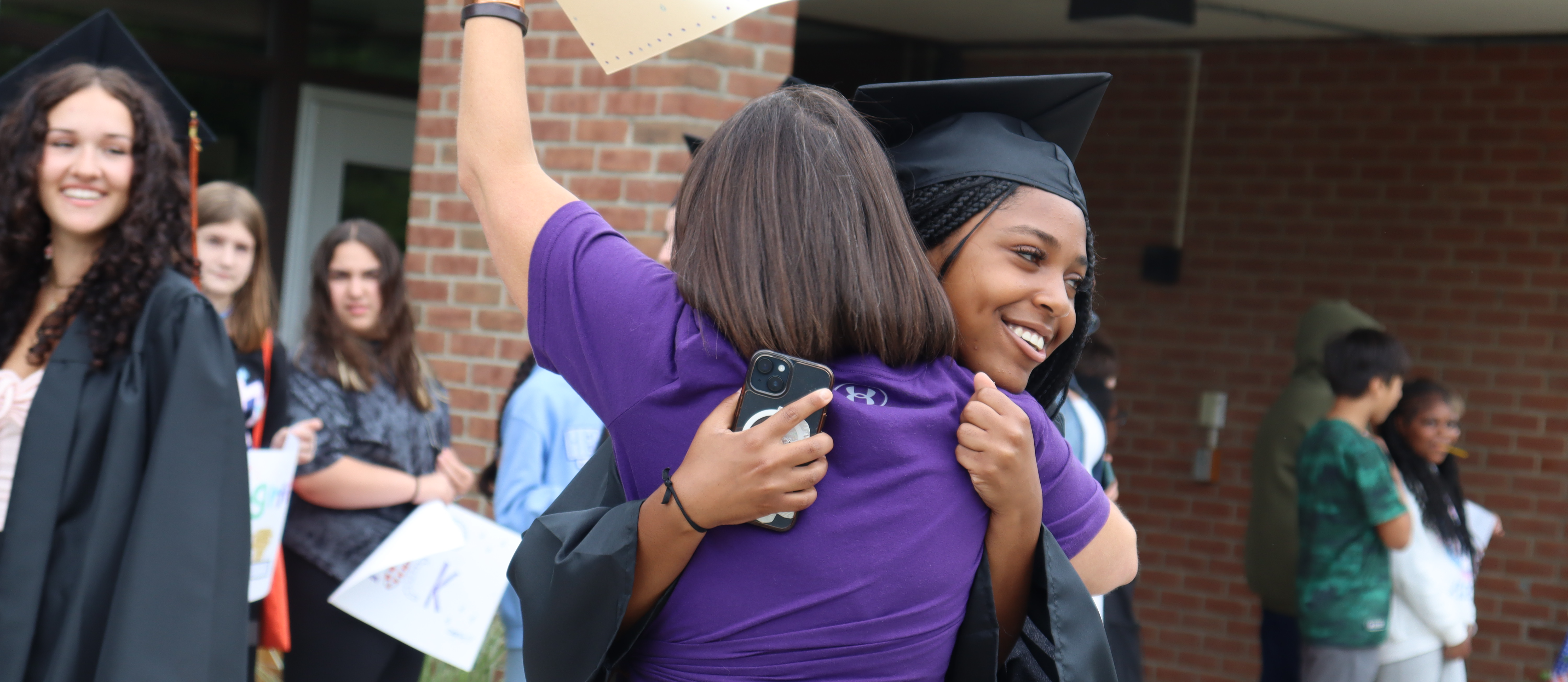 A graduate hugs a teacher