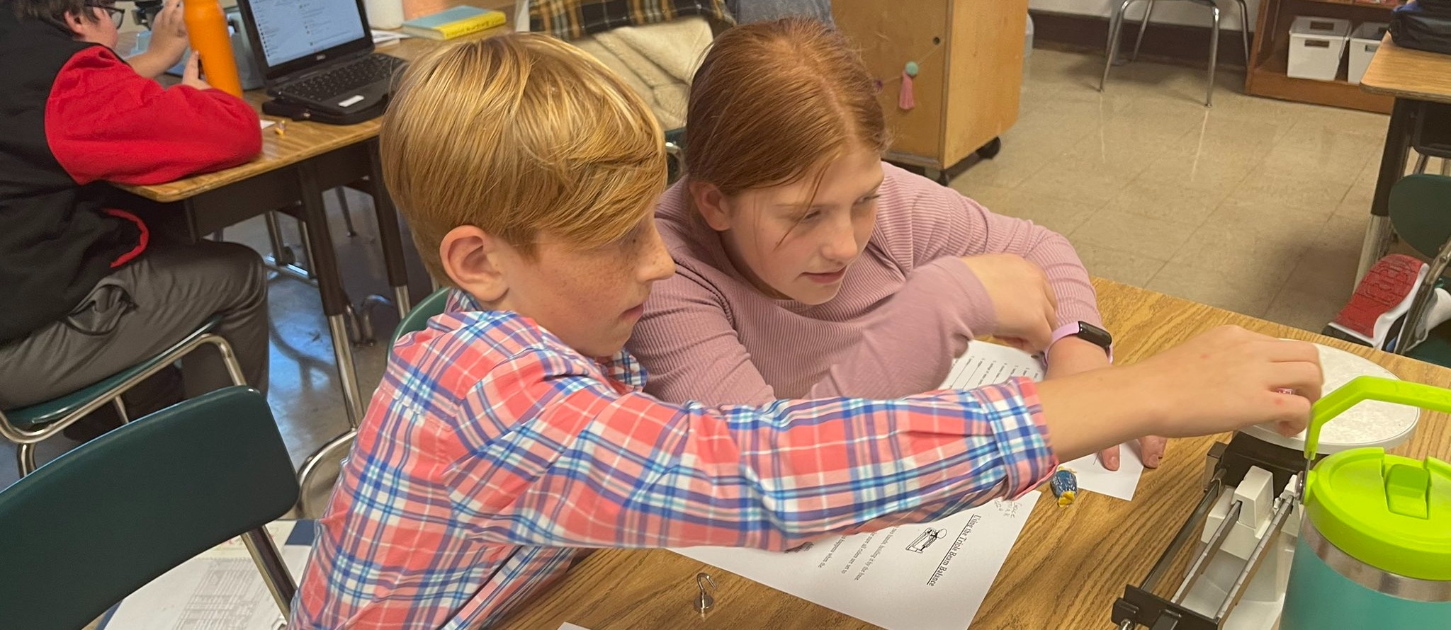 Two students using a scale