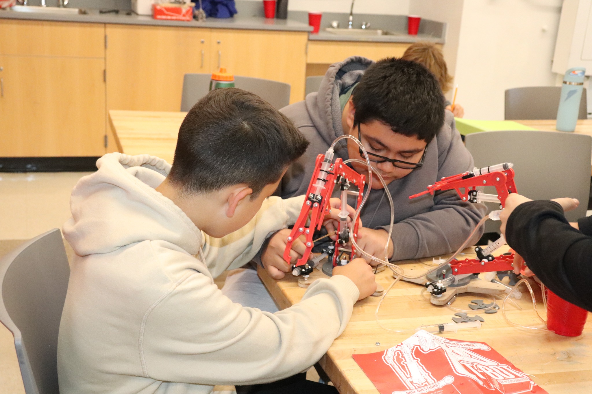 Students building hydraulic arms
