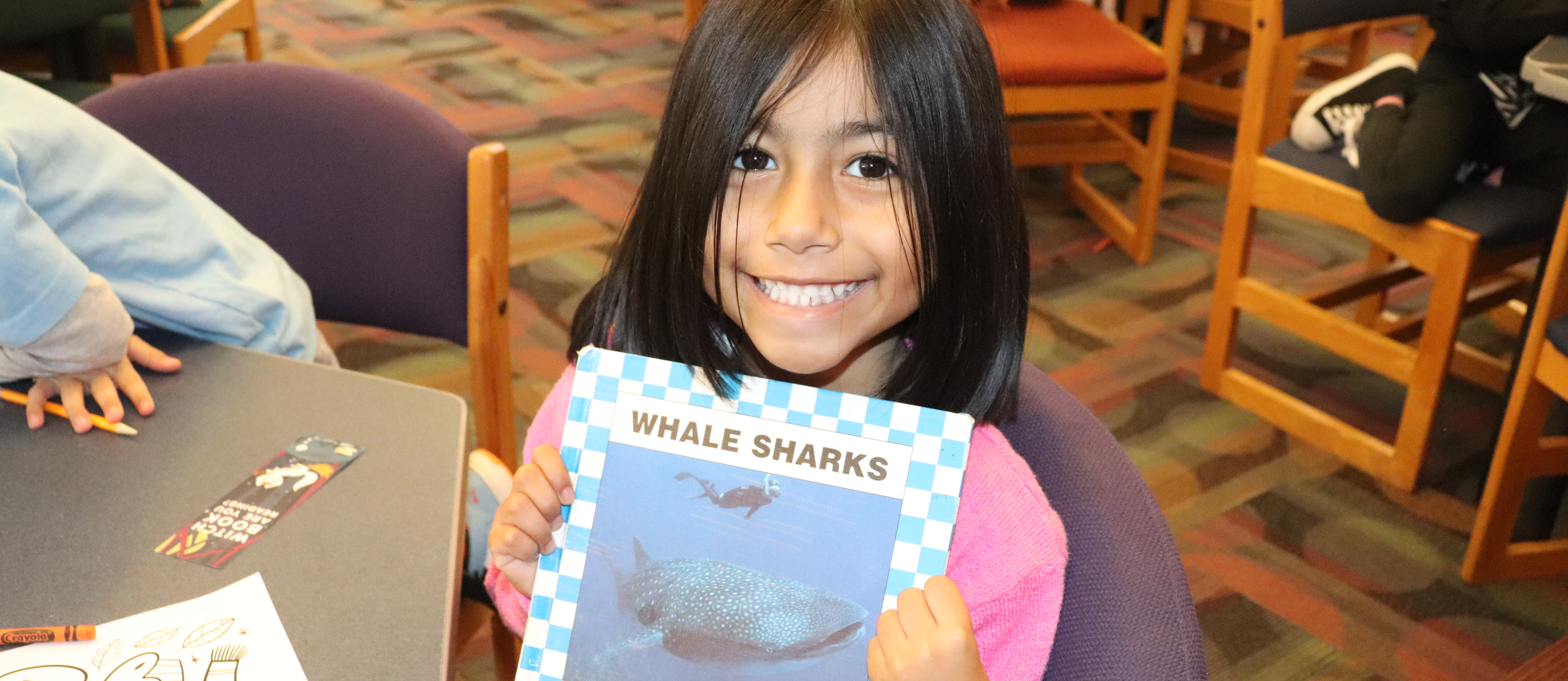A student holding a book about sharks