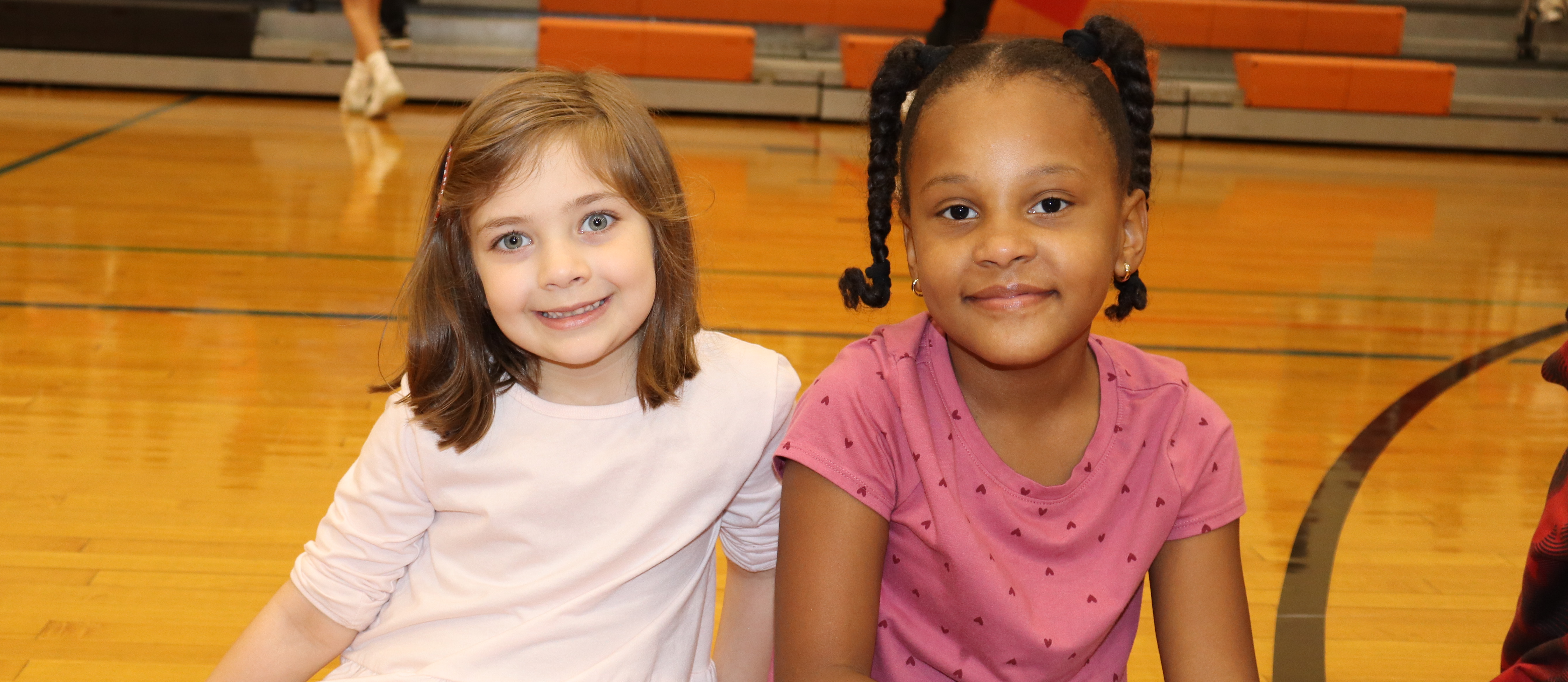 To students sitting on a gym floor