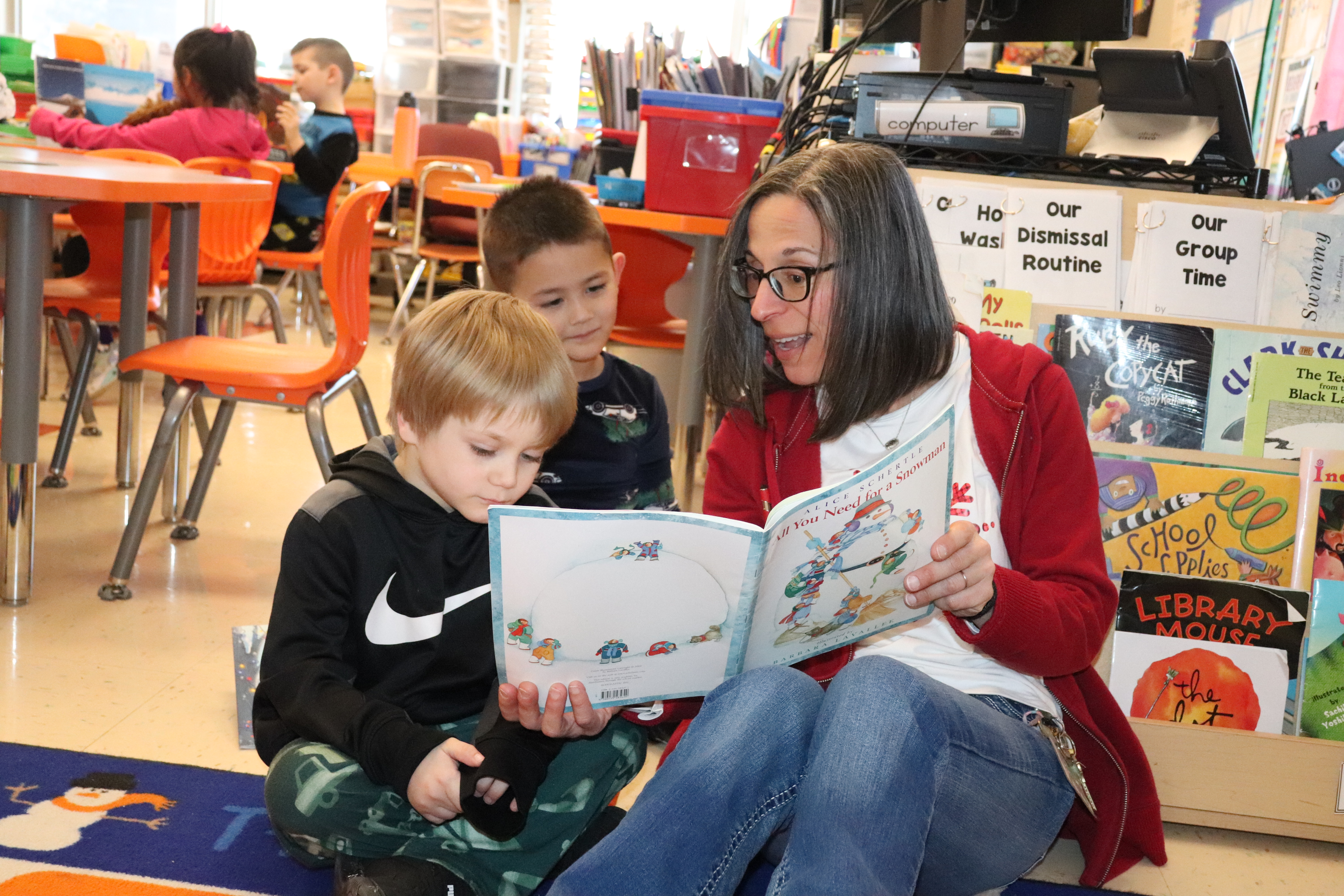 A teacher reading to two students