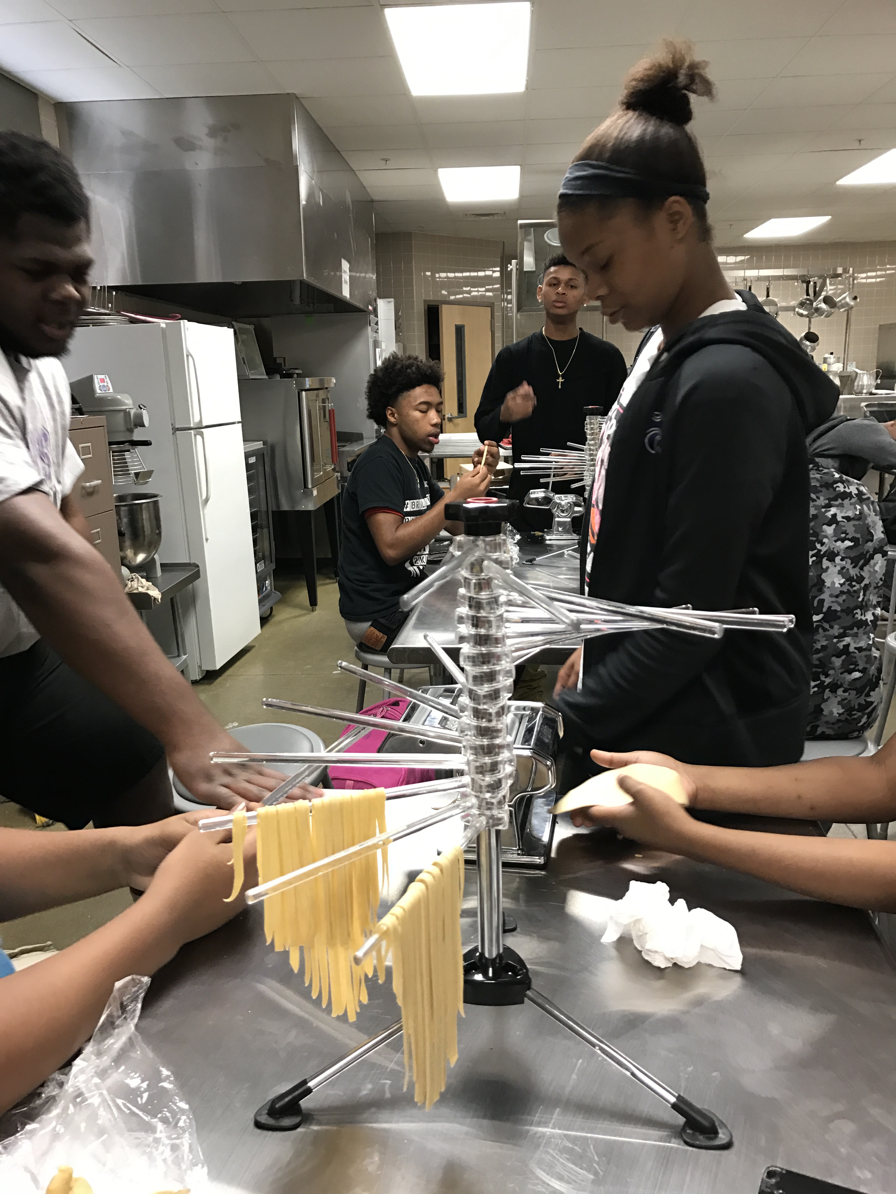 A photo of some students making pasta.