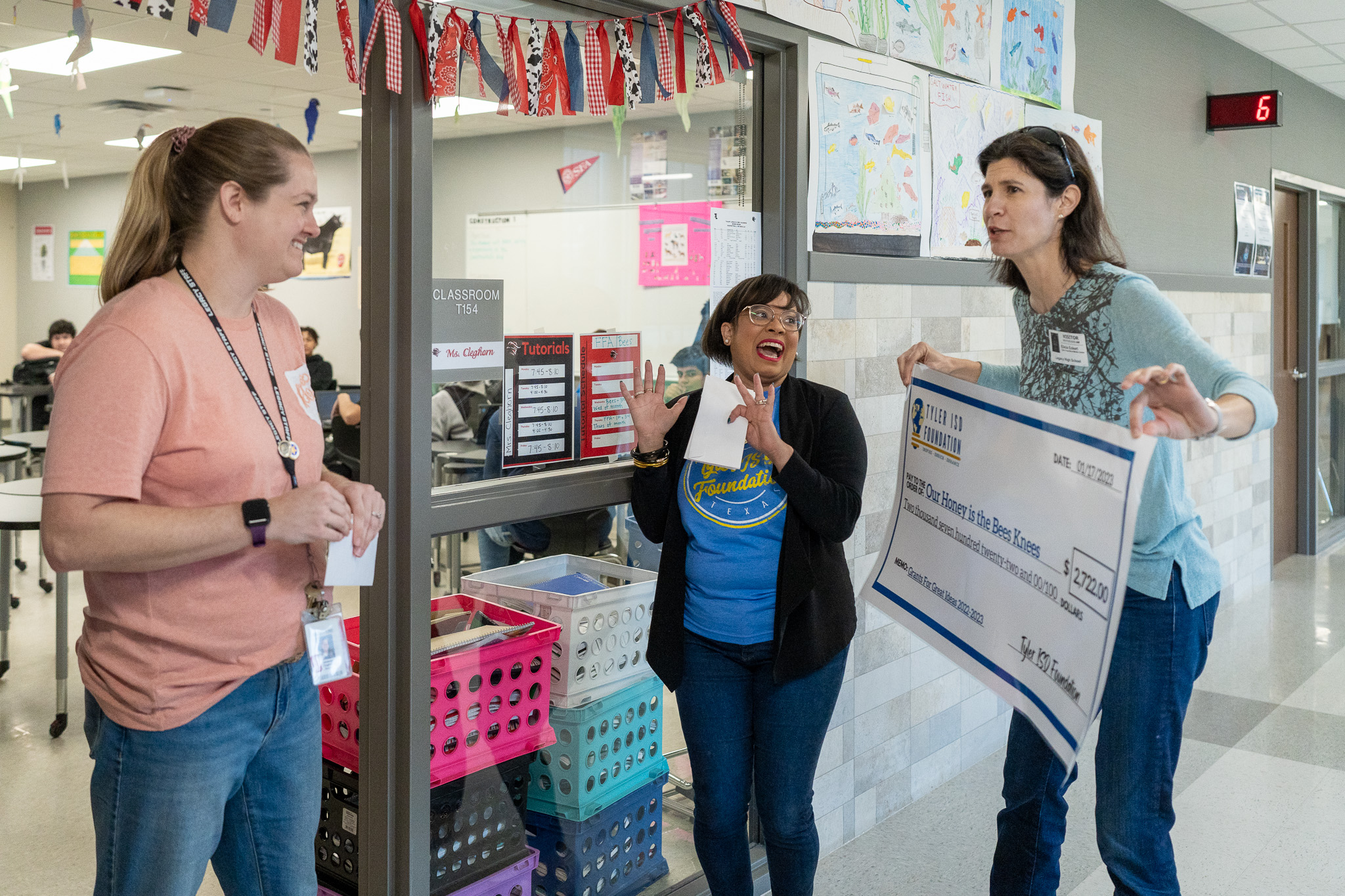 woman getting surprised with a giant check for a grant