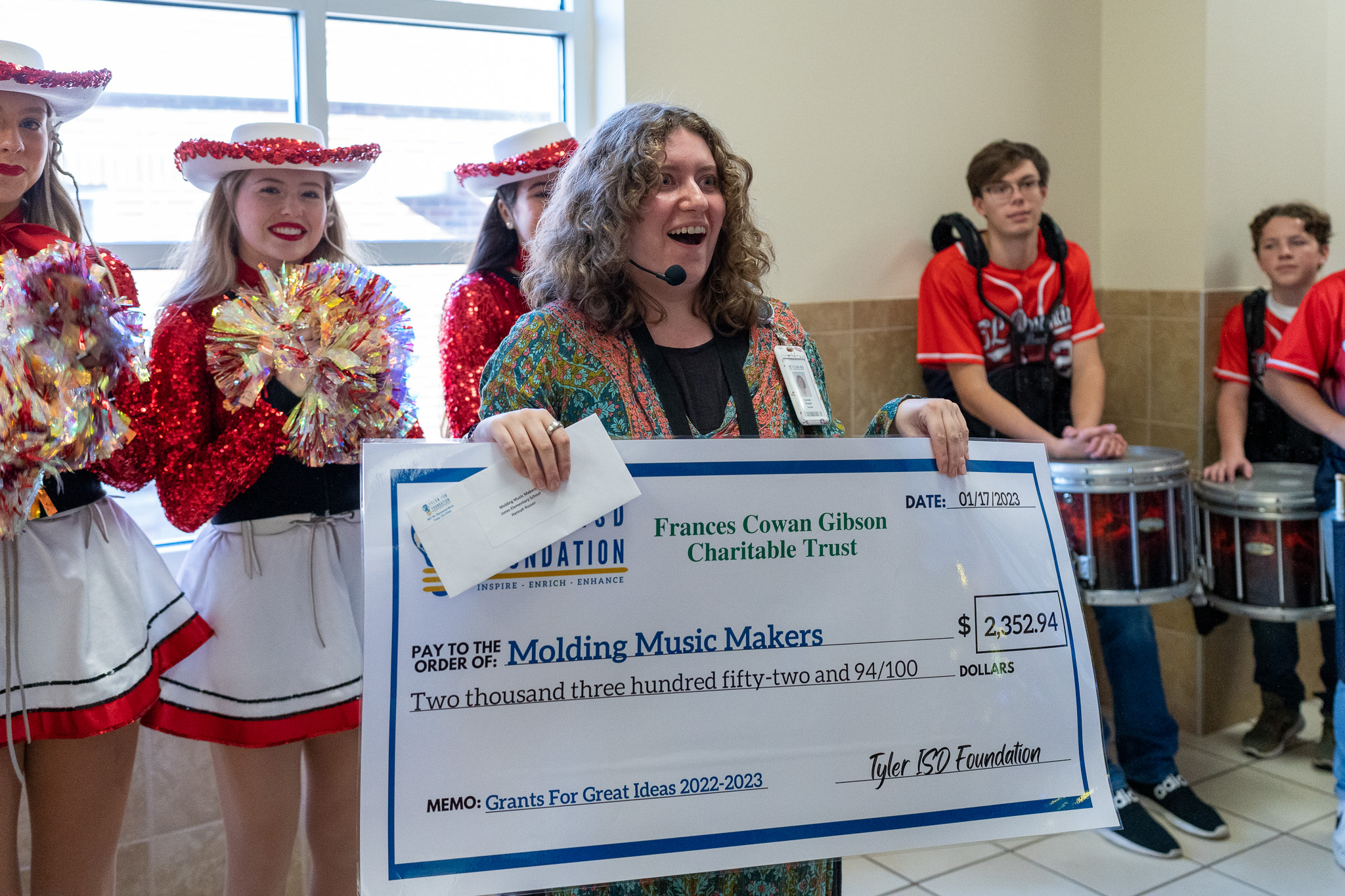 woman getting surprised with a giant check for a grant