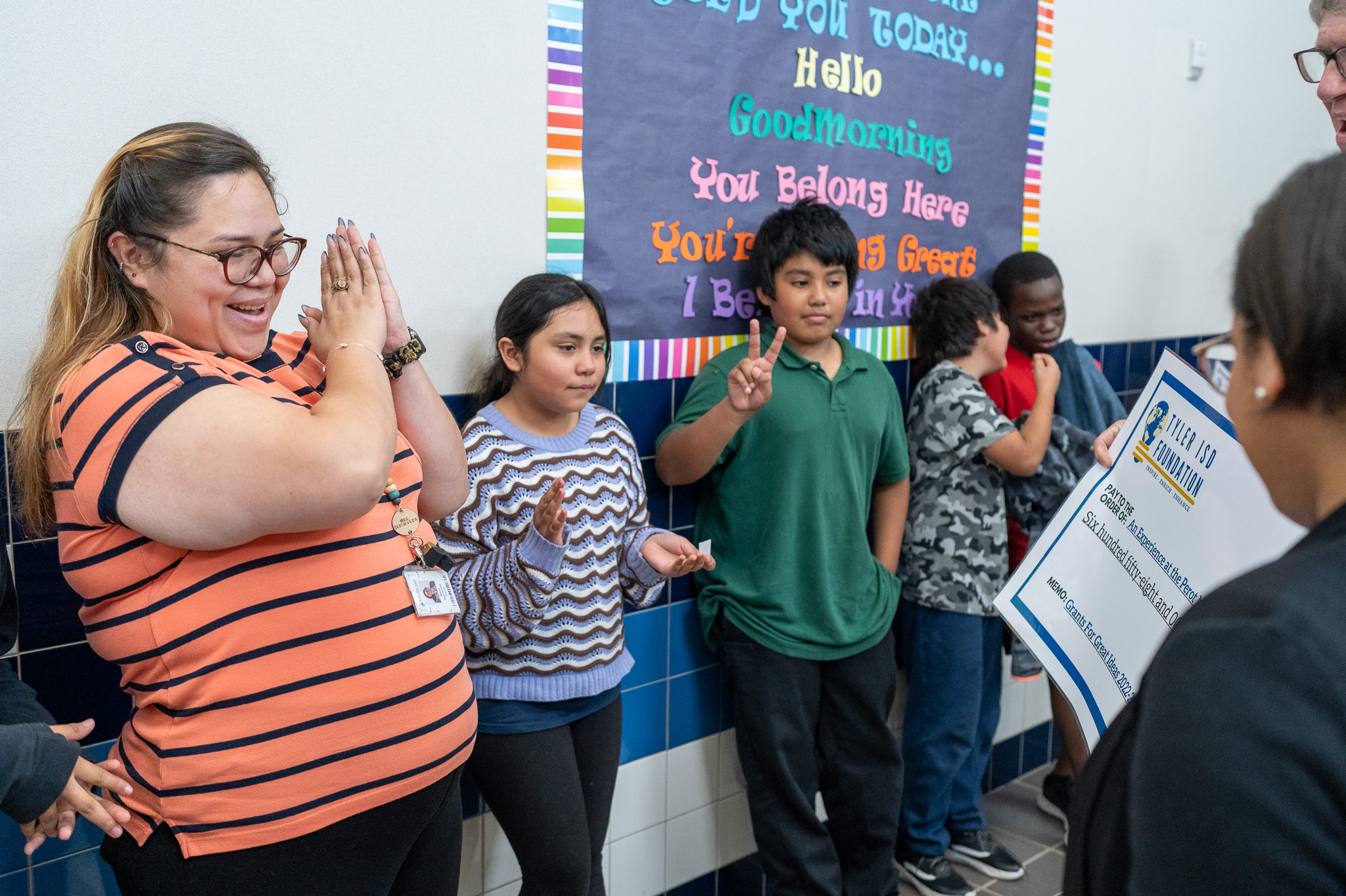 woman getting surprised with a giant check for a grant