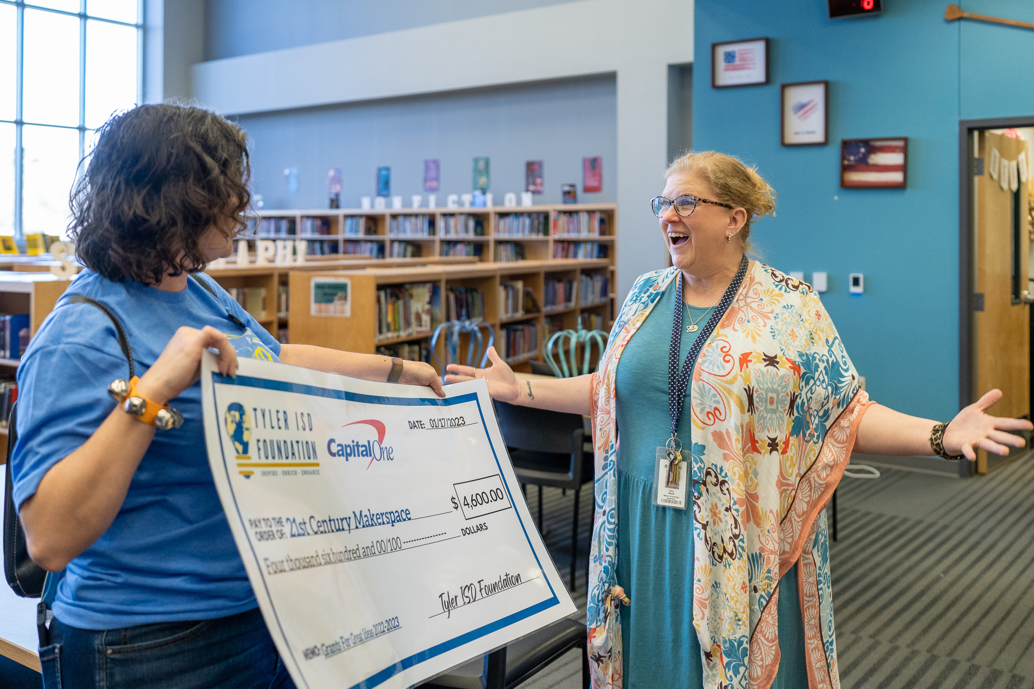 woman getting surprised with a giant check for a grant