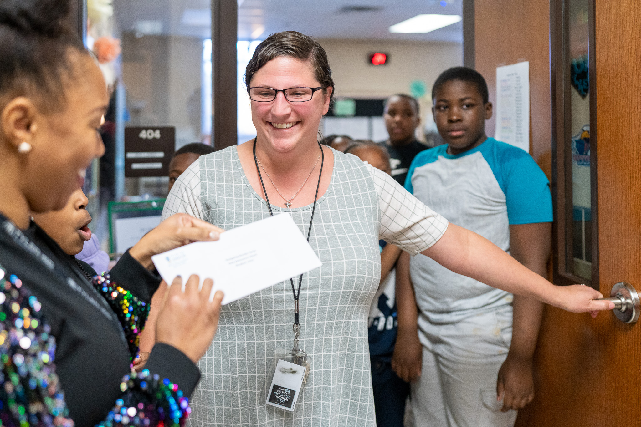 woman getting surprised with a giant check for a grant