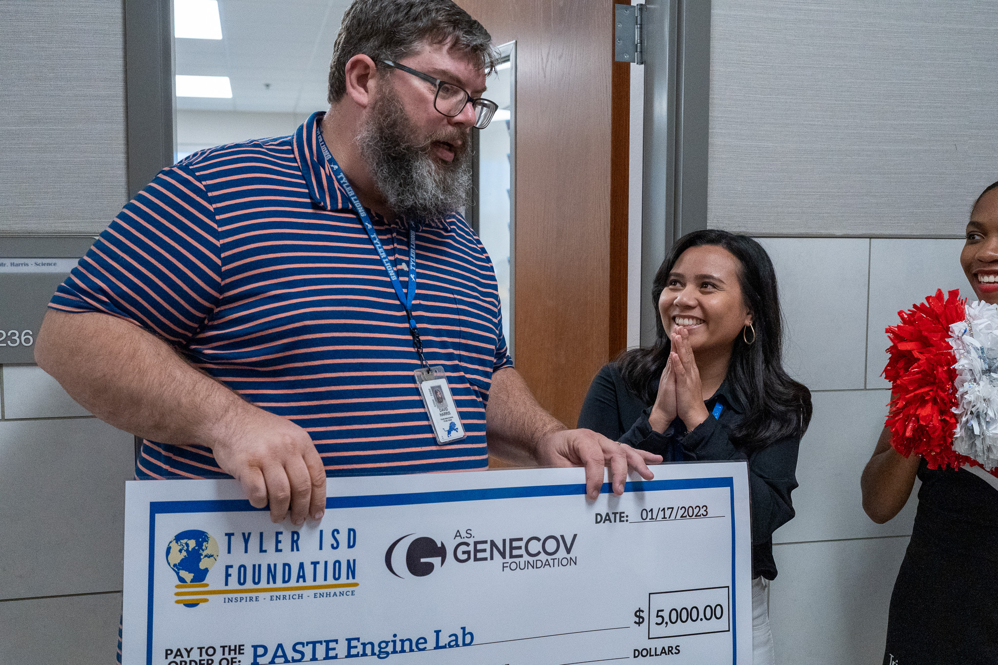 man getting surprised with a giant check for a grant