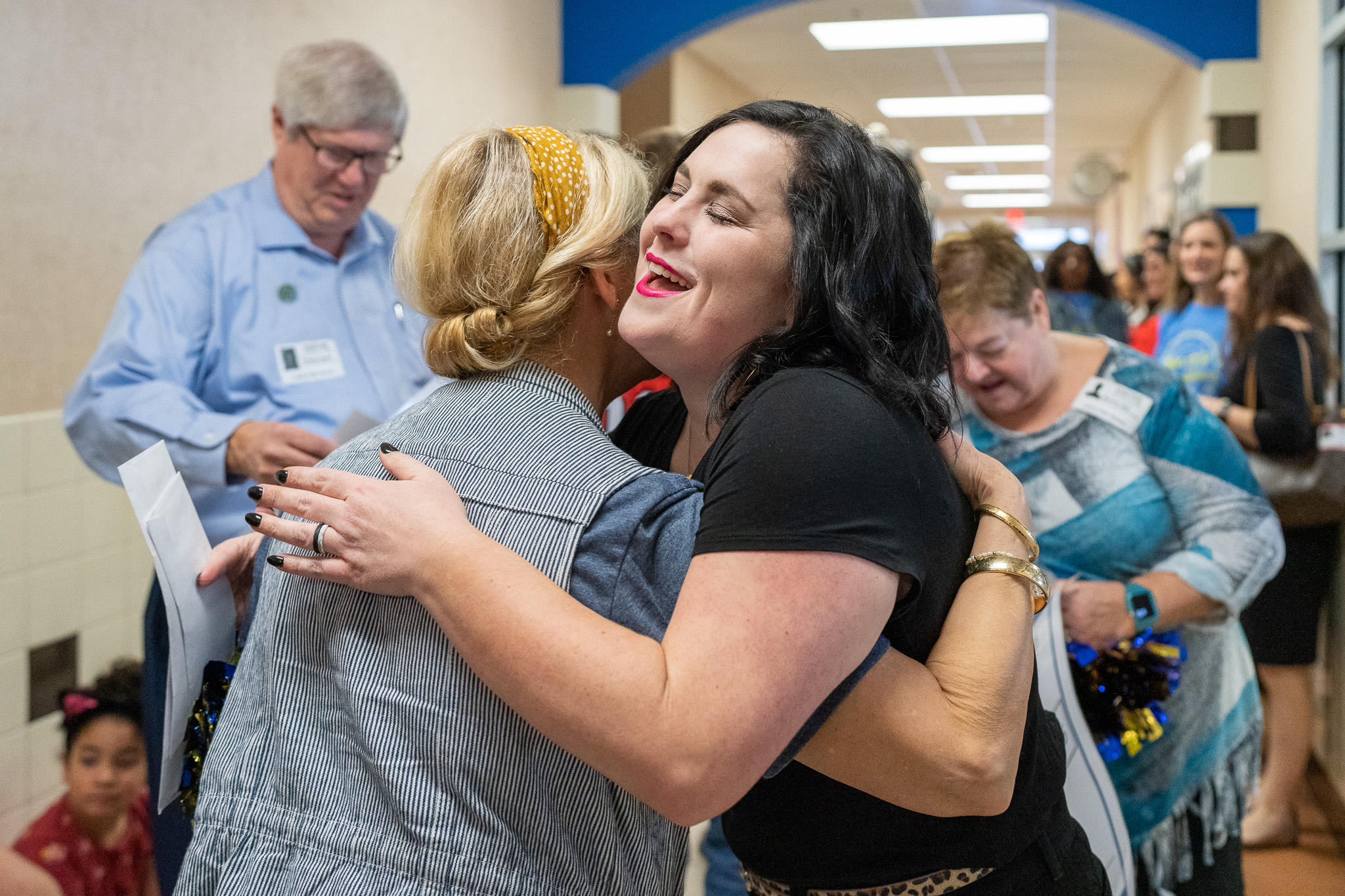 woman getting surprised with a giant check for a grant