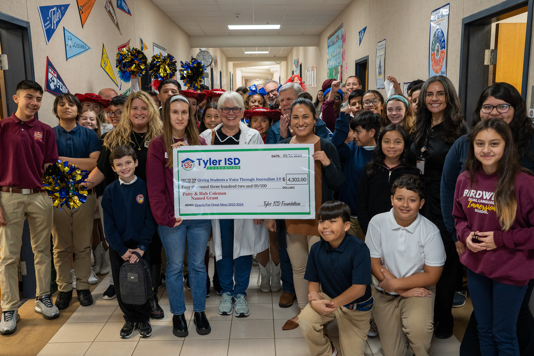 group of adults and students holding giant check