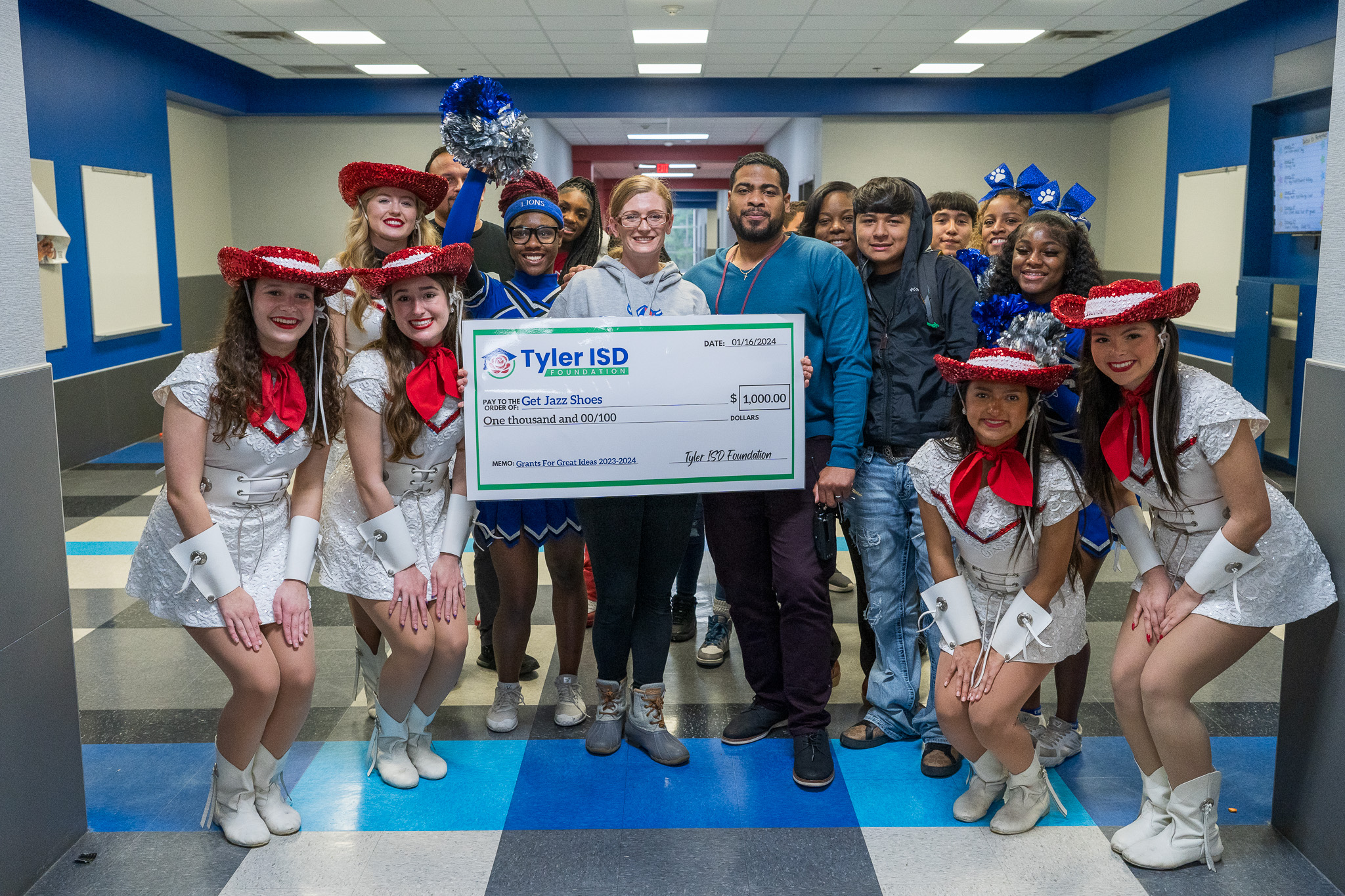 group of adults and students holding a giant check