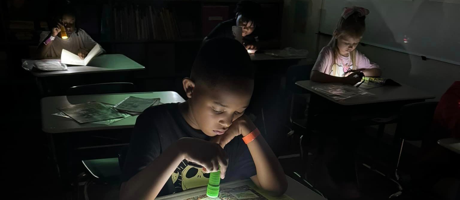 student reading with flashlight