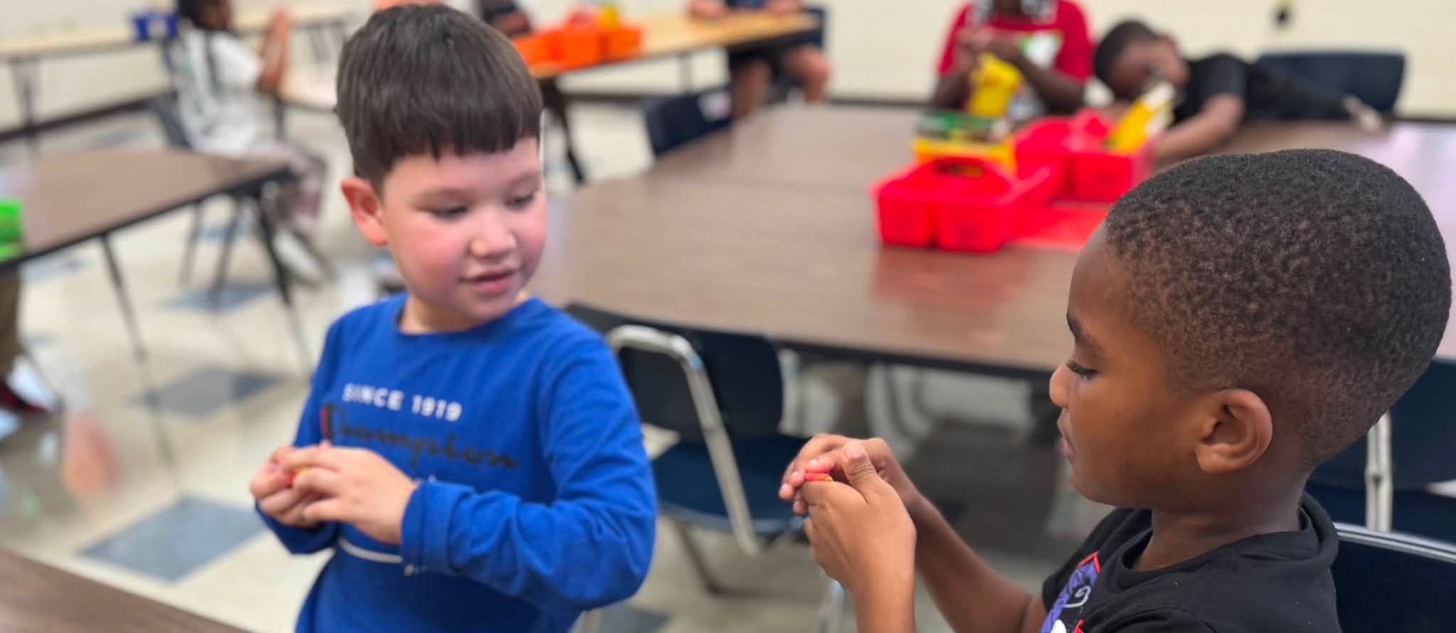 two boys showing clay to each other after they combined colors