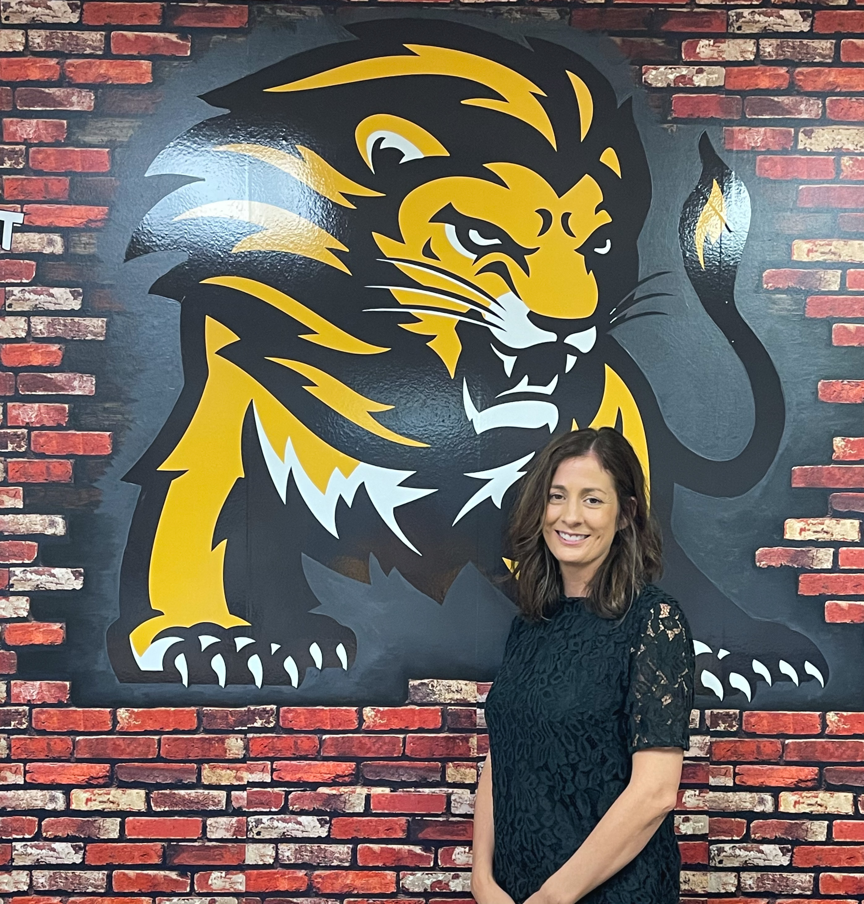 Principal Kelly Williams stands in front of the Salem Lion logo in the Bradie Shrum Elementary front office.