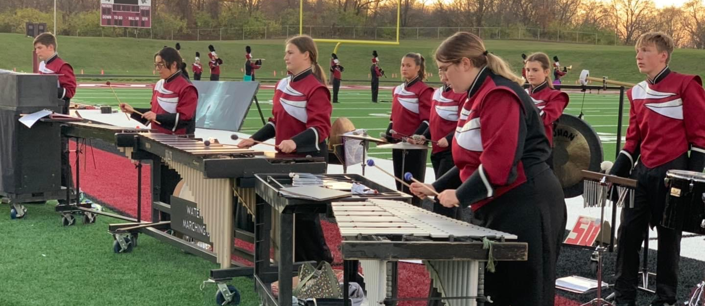 WHS Marching Band Percussion Session performing outdoors in full uniform 