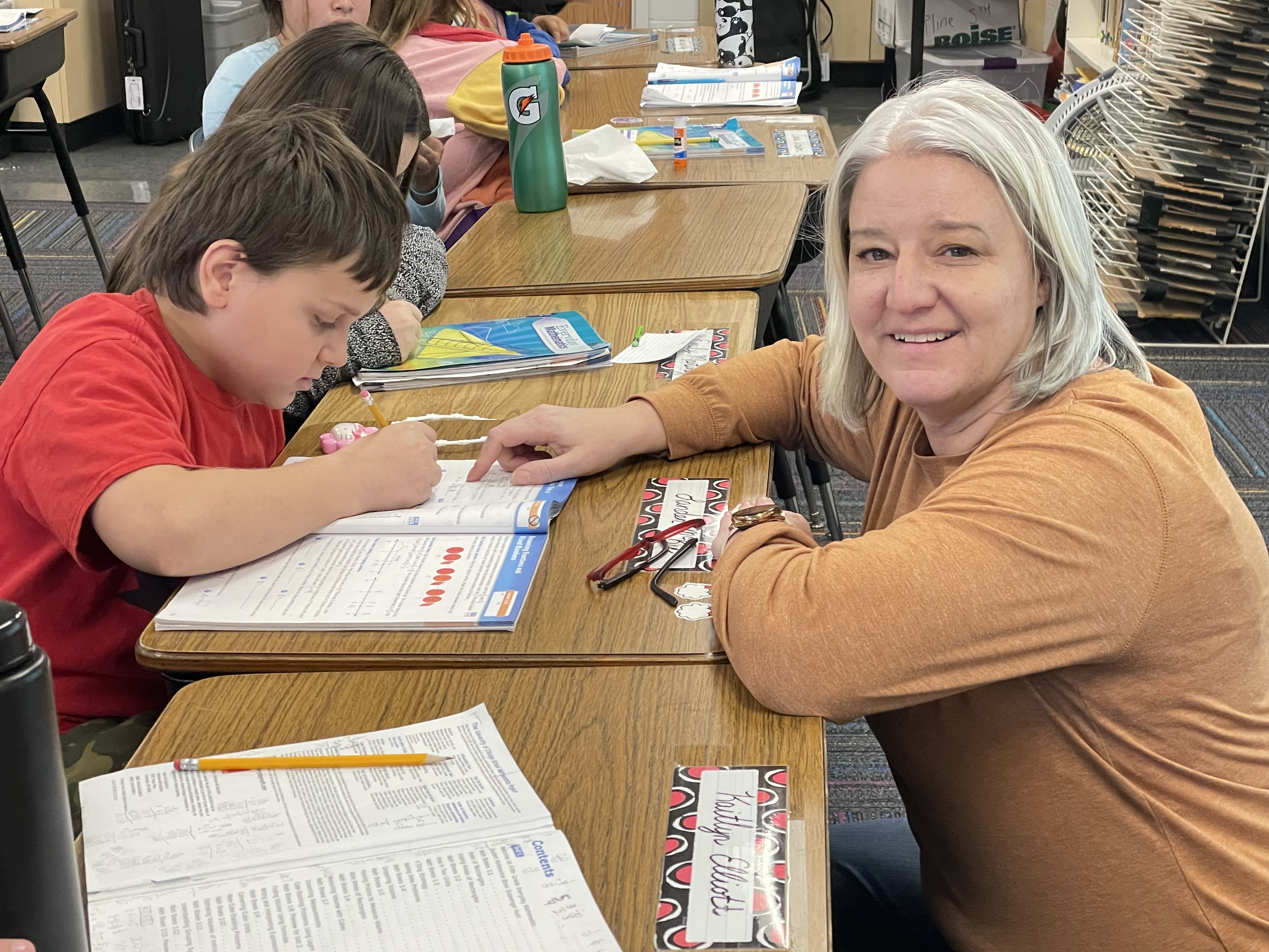 Lori Pline works with a student in her classroom