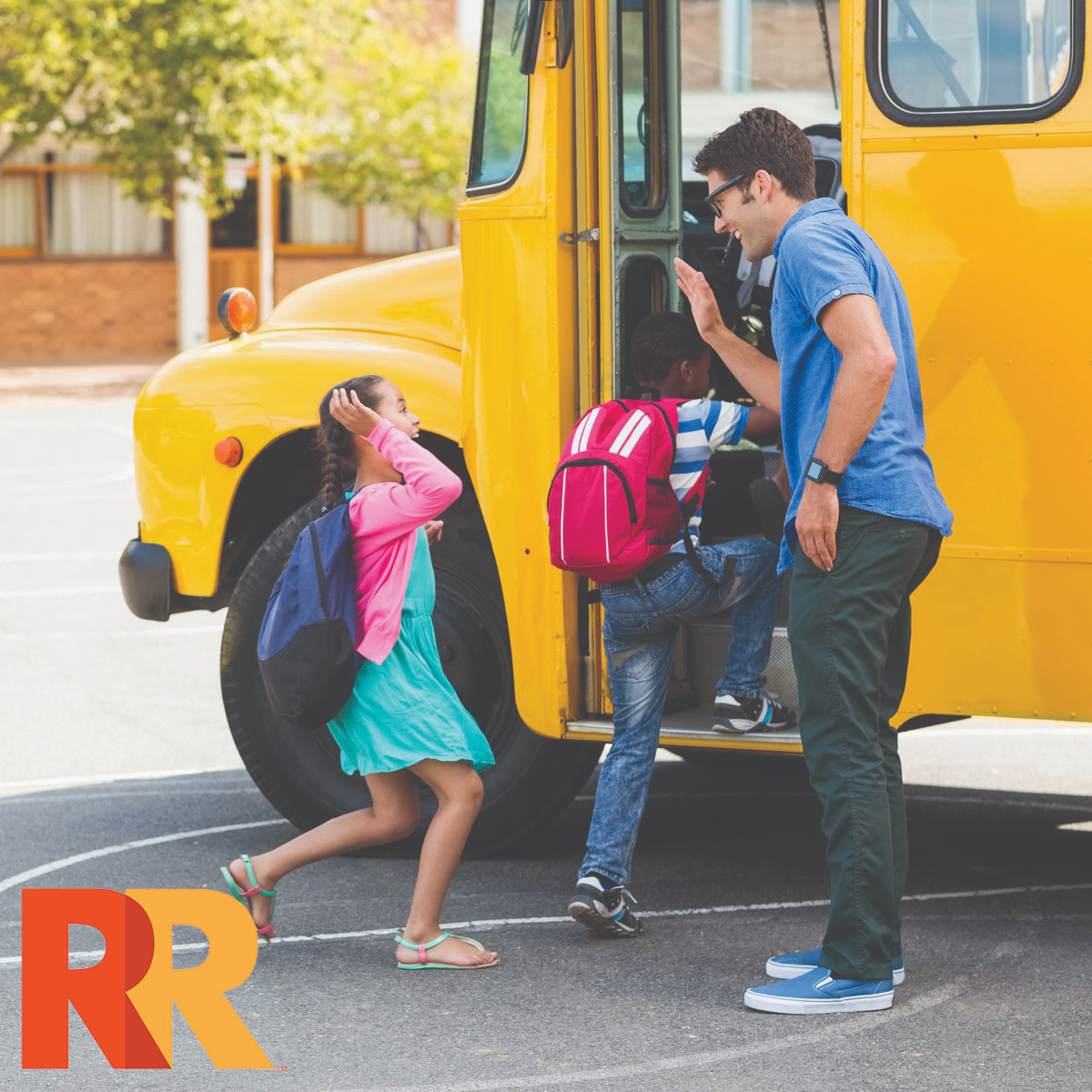 Bus driver giving students a high five as they board the school bus in a parking lot.
