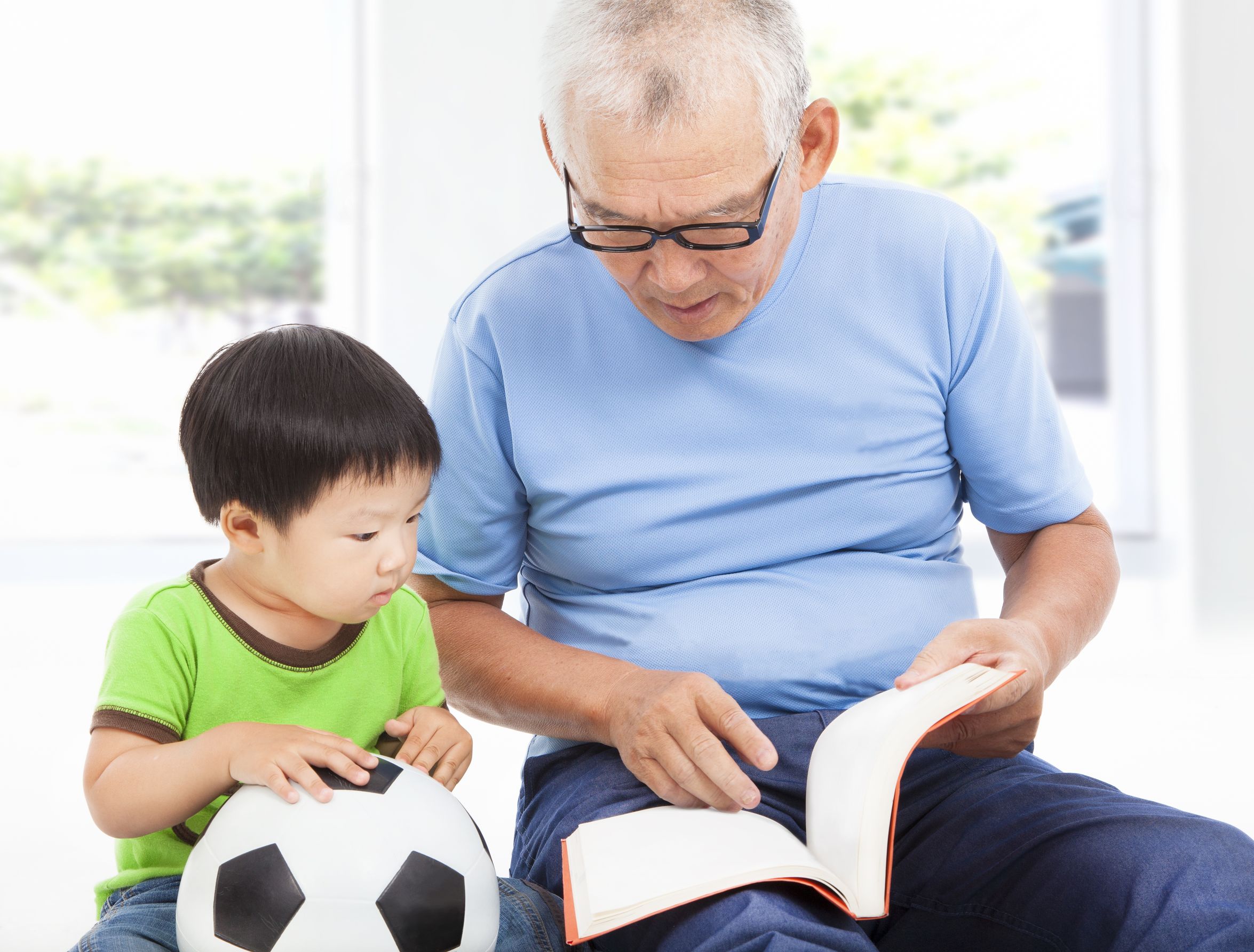 Older man reading to a child.