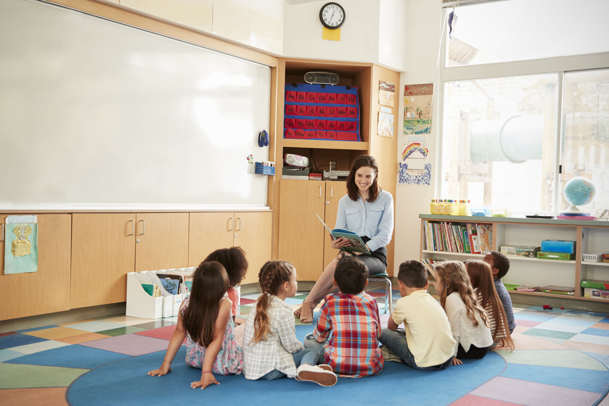 volunteer reading to a group of kindergarten students